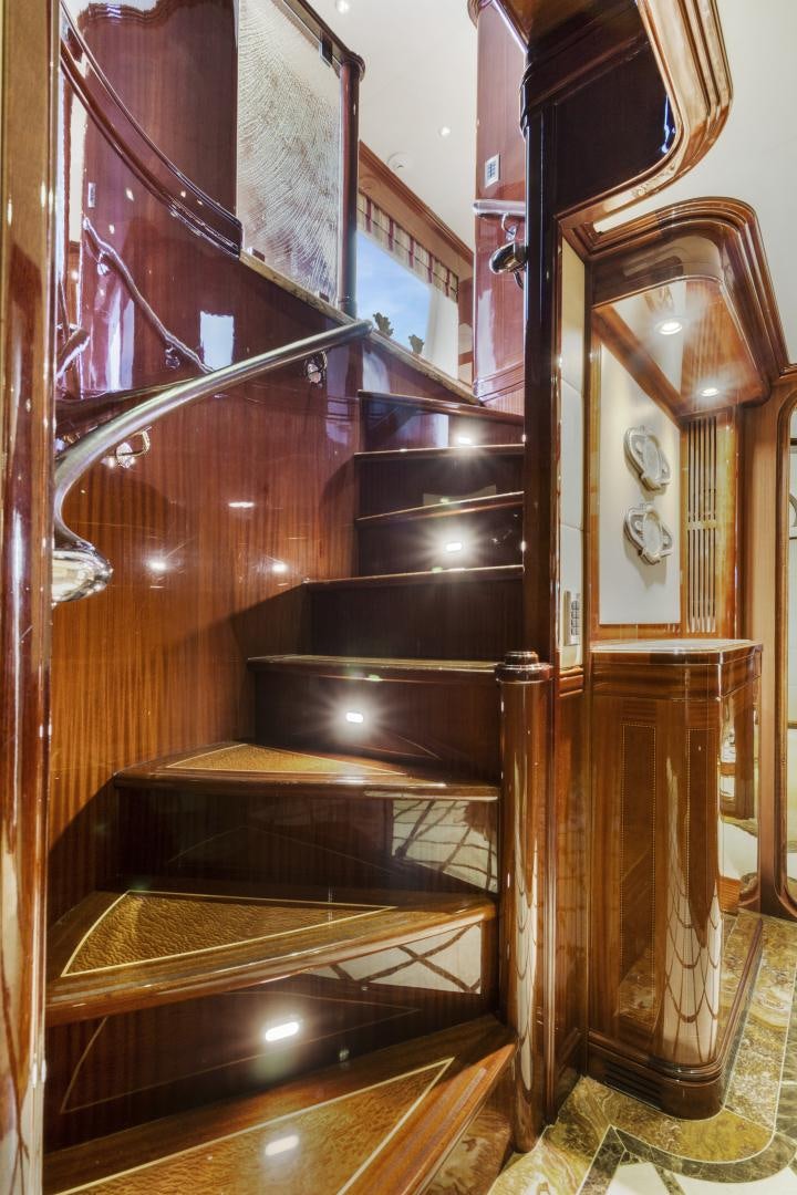 a wooden staircase with a clock aboard SERQUE Yacht for Sale