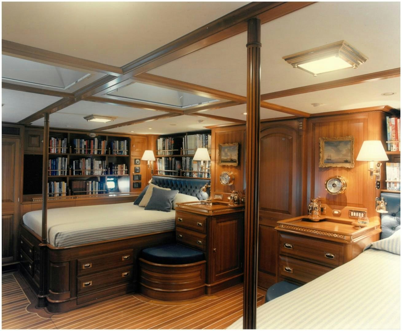 a bedroom with a bed and a bookcase aboard ANAKENA Yacht for Sale