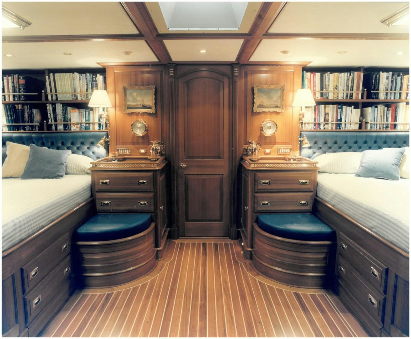 a bedroom with a bed and a bookcase aboard ANAKENA Yacht for Sale
