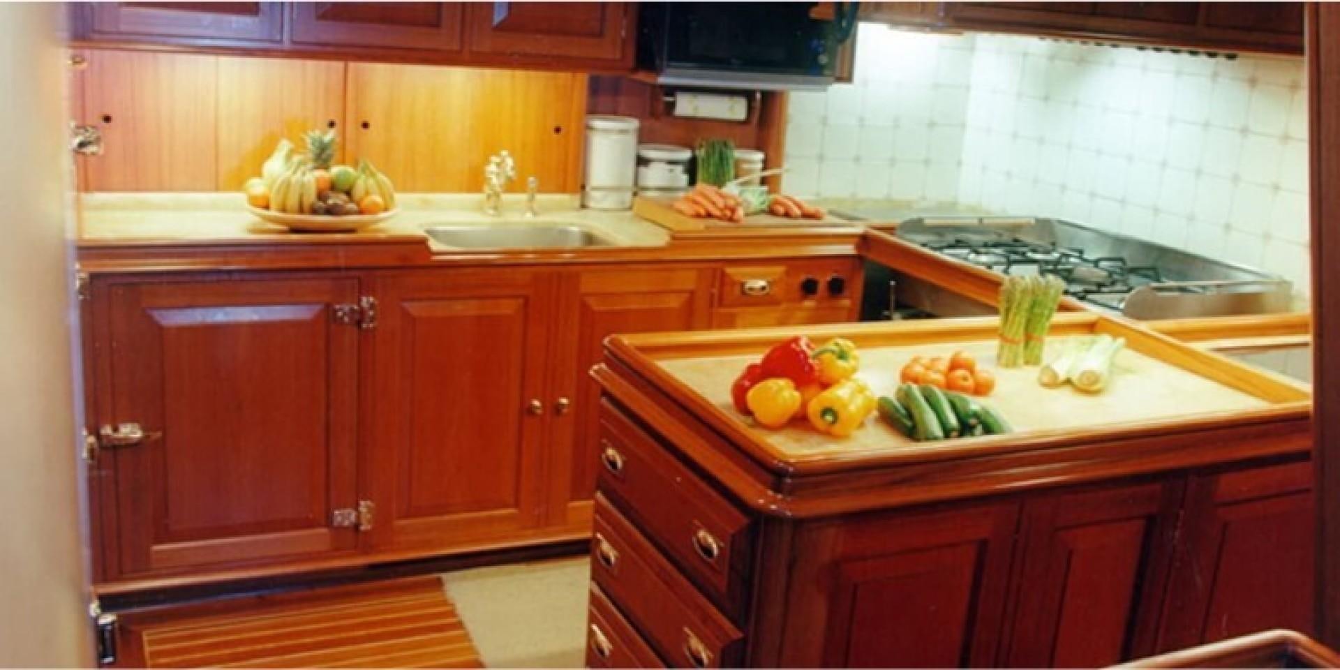a kitchen with wooden cabinets aboard ANAKENA Yacht for Sale