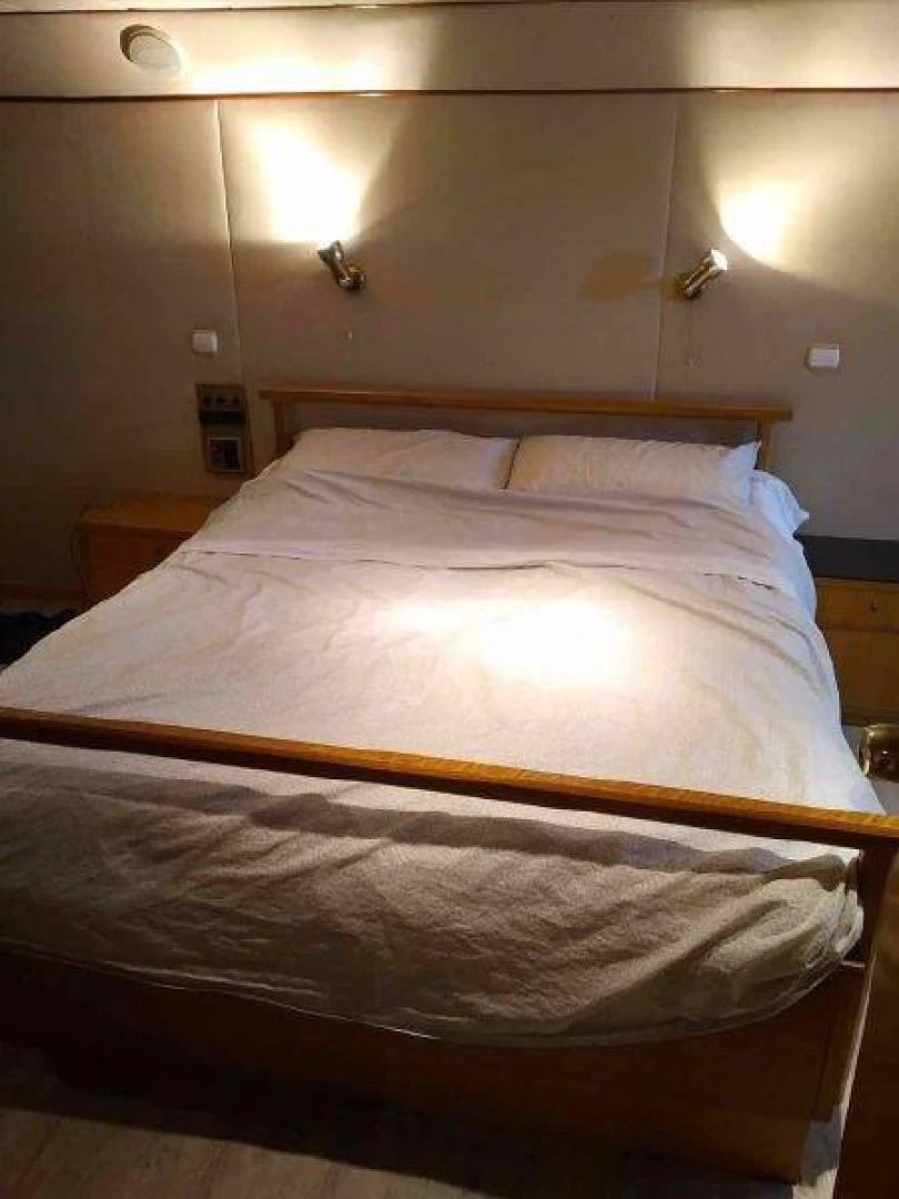 a bed with a white comforter aboard STAR ALLIANCE Yacht for Sale