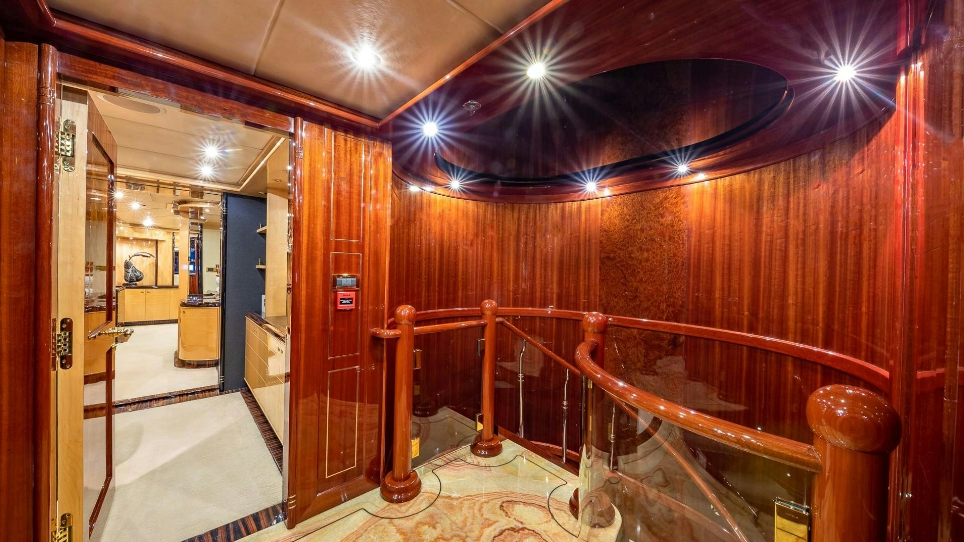 a hallway with wood walls and a chandelier aboard LADY LEILA Yacht for Sale