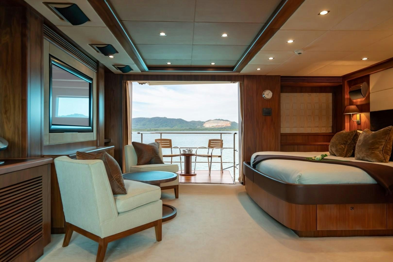 a room with a bed and a table and chairs aboard ABOUT TIME Yacht for Sale