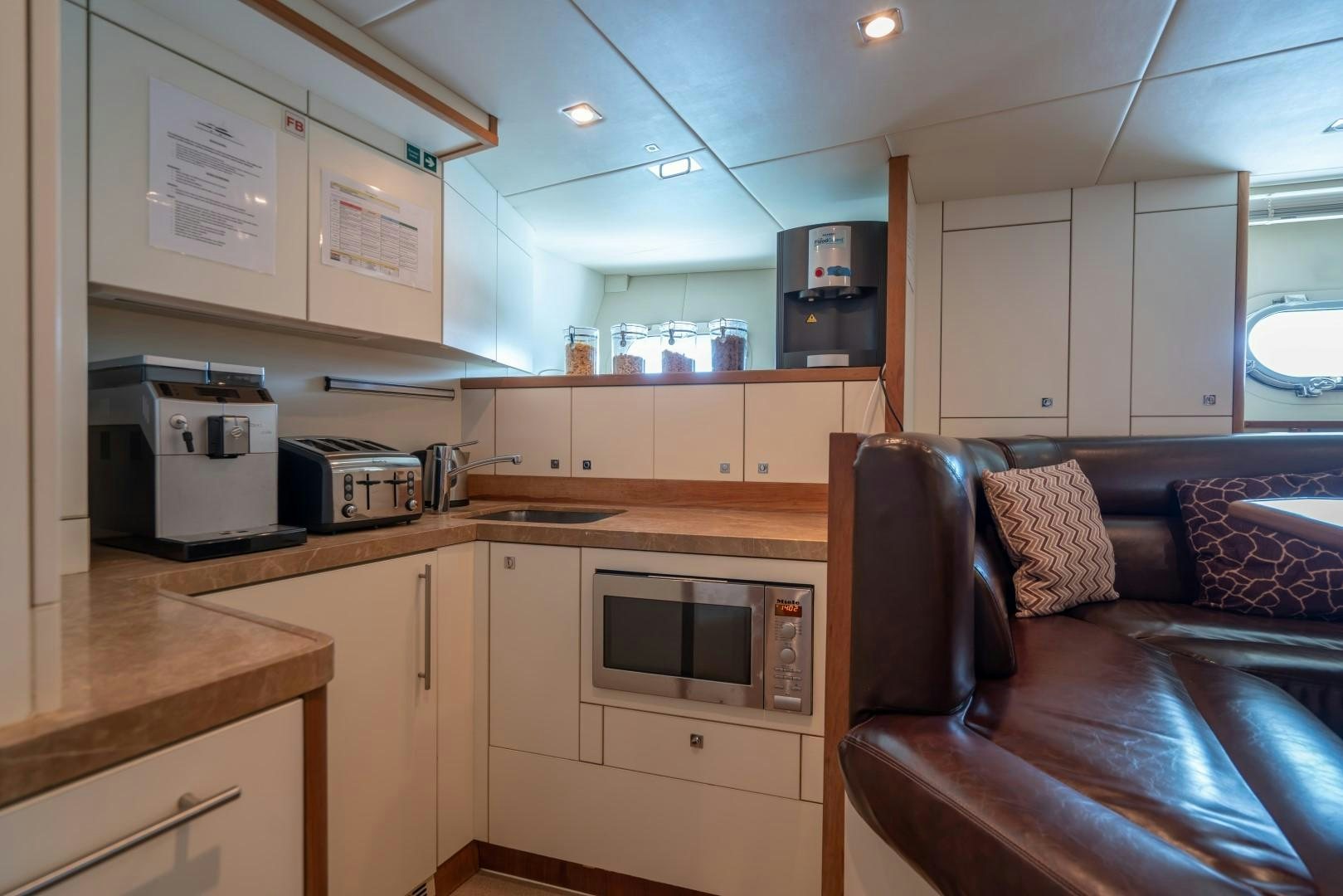 a kitchen with a couch and a microwave oven aboard ABOUT TIME Yacht for Sale