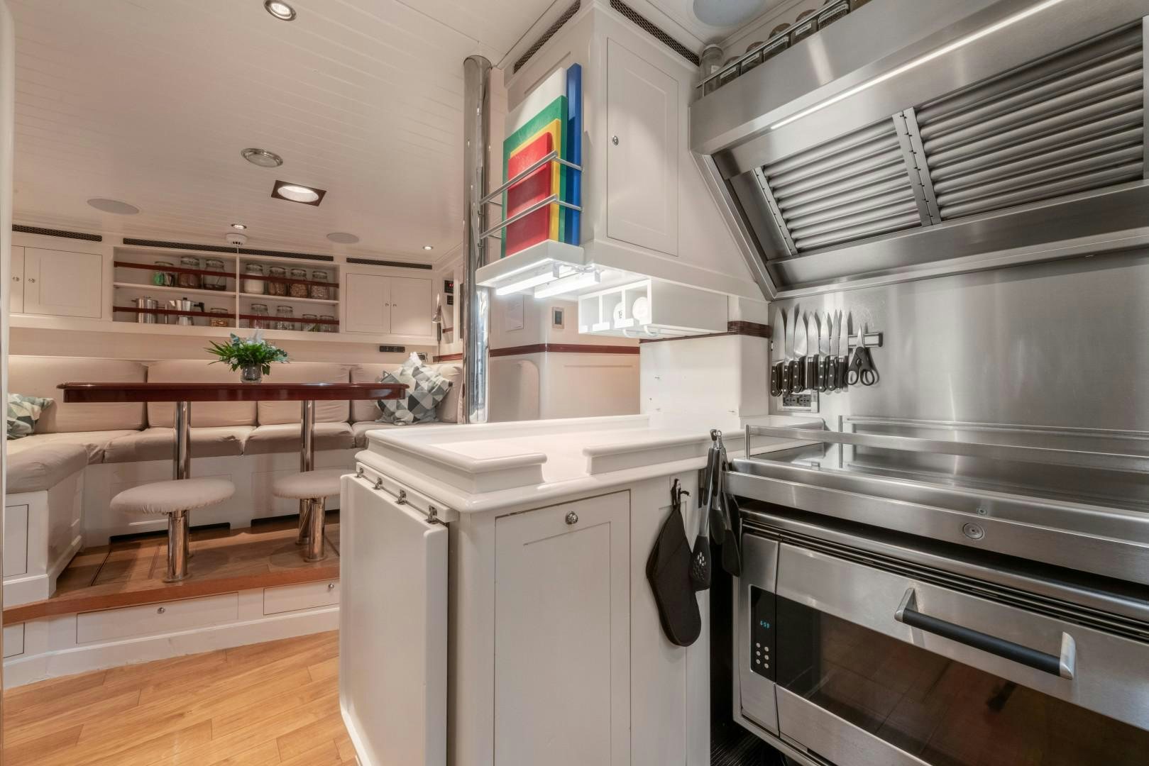 a kitchen with a stove and a table aboard RAINBOW Yacht for Sale