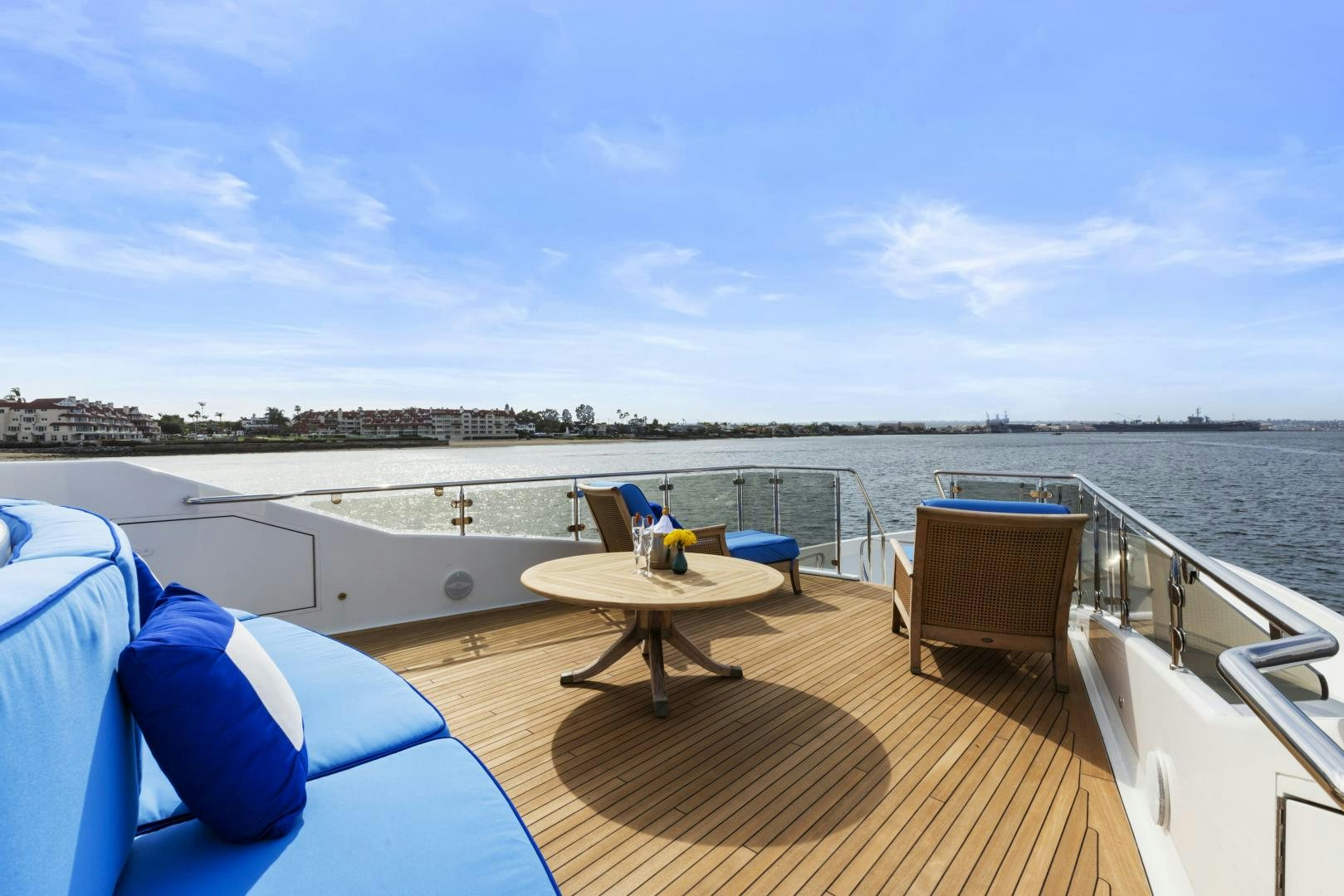 a deck with a table and chairs on it and a body of water in the background aboard APHRODITE Yacht for Sale