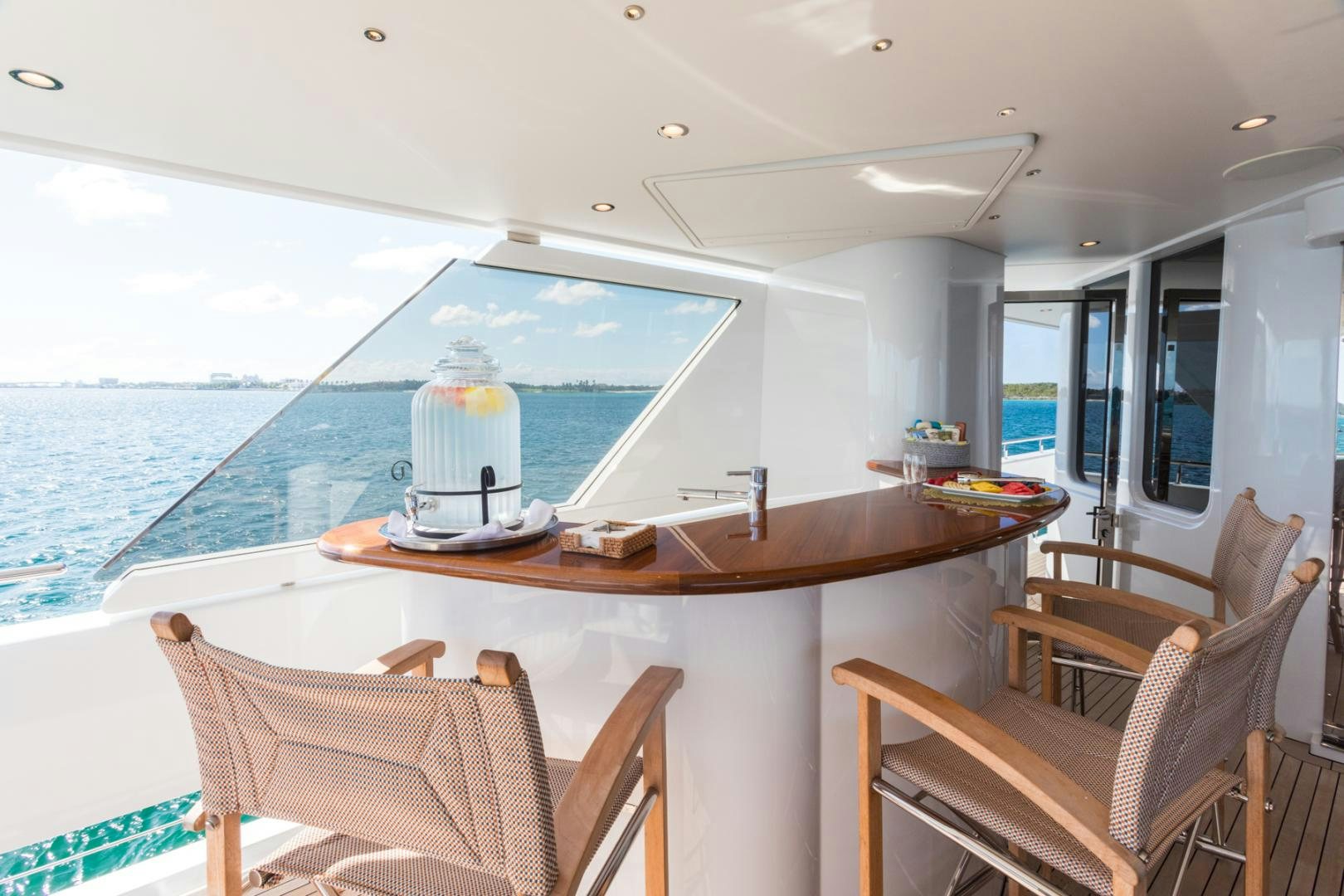 a table with chairs and a view of the ocean aboard ARMS REACH Yacht for Sale