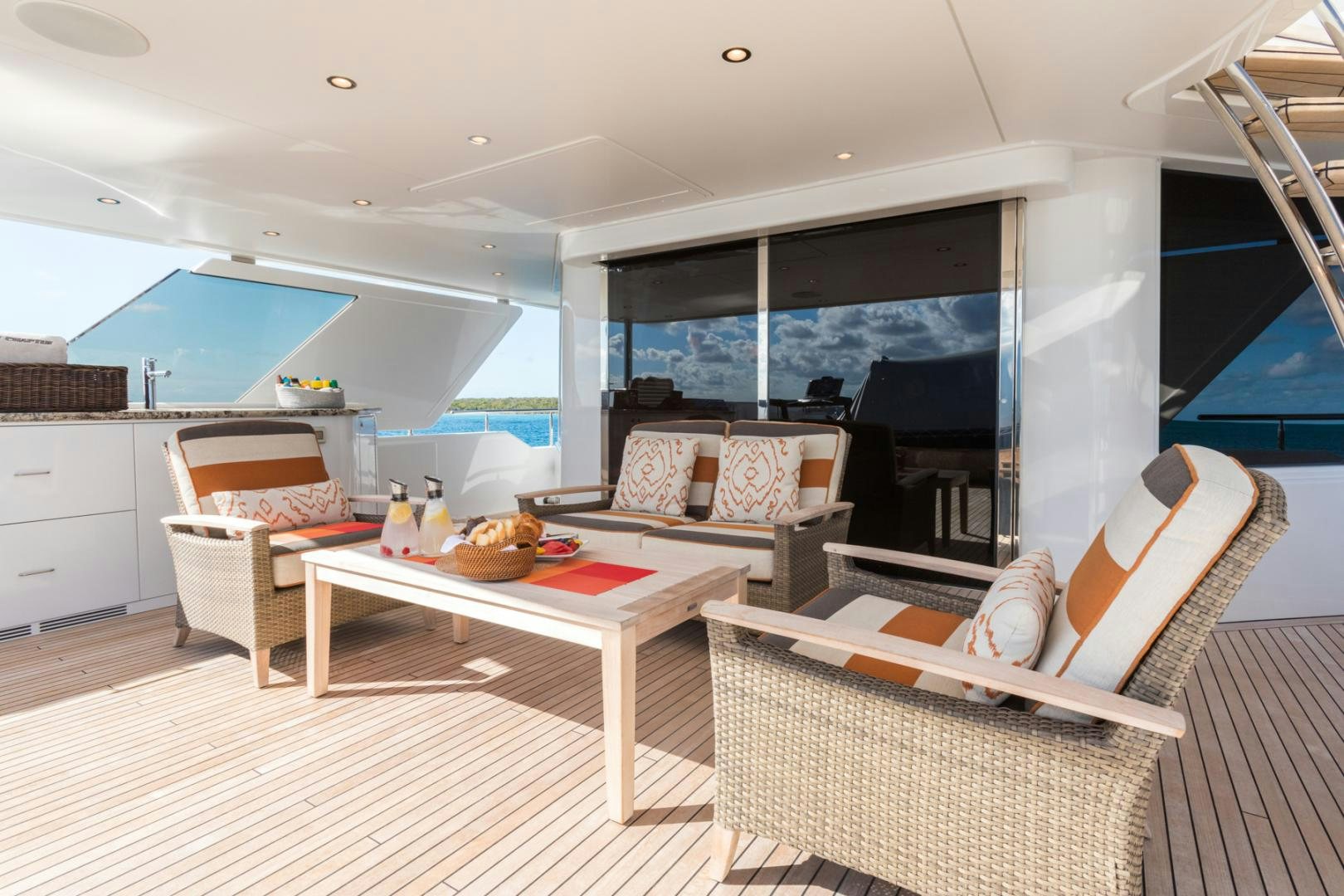 a living room with a table and couches aboard ARMS REACH Yacht for Sale