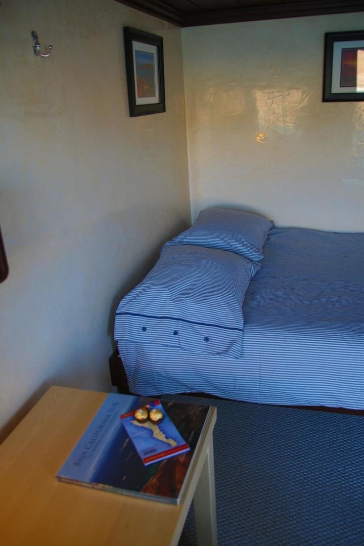 a bed with a blue sheet aboard NO NAME Yacht for Sale