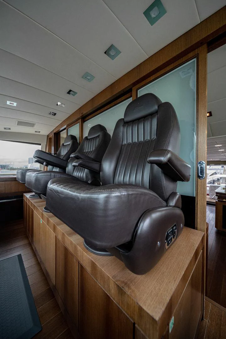 a black leather chair on a wooden table aboard KABIR 130S STABILIZED WITHOUT TAKING AWAY FROM PERFORMANCE (COPY) Yacht for Sale
