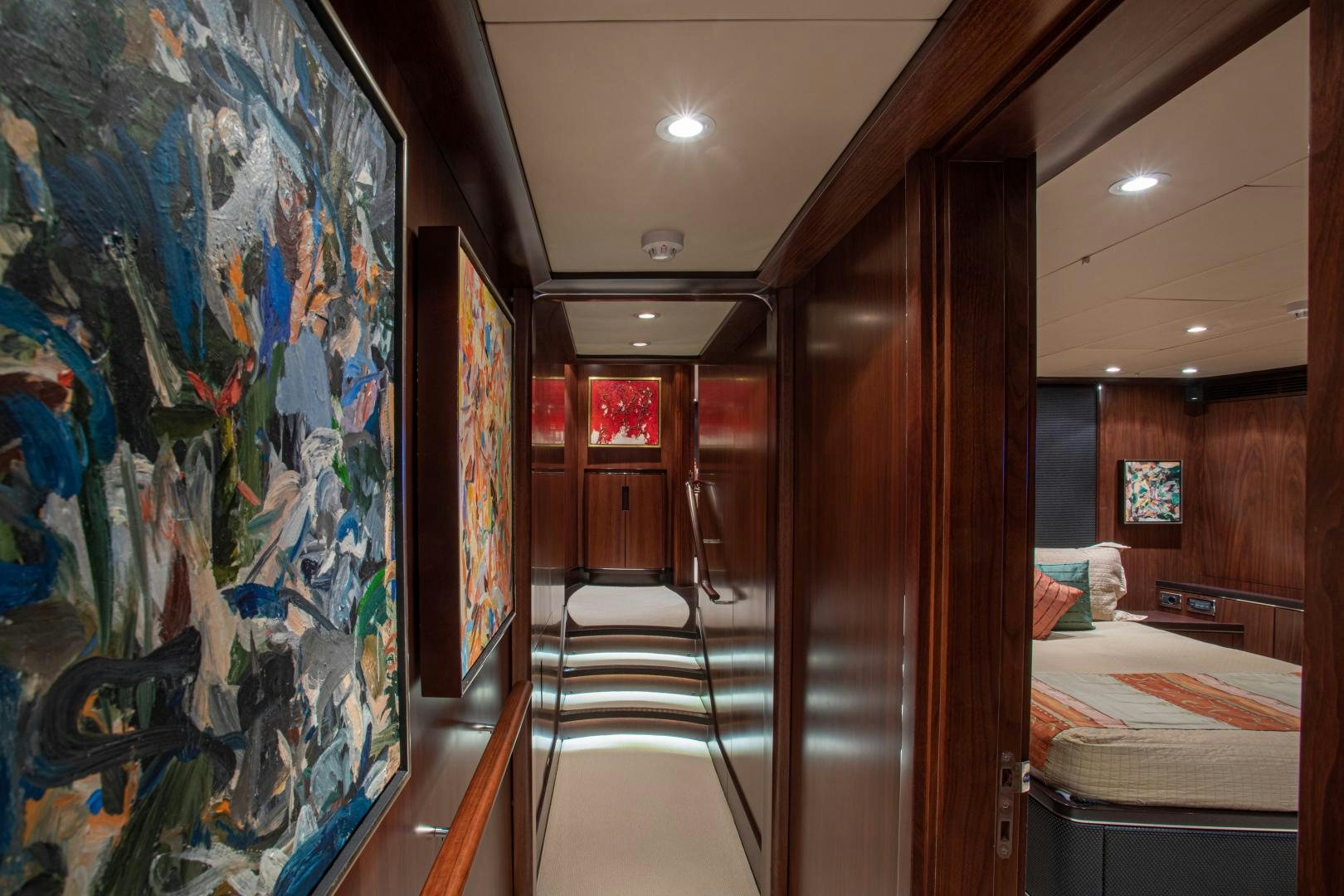 a room with a bed and paintings aboard MIA CARA Yacht for Sale
