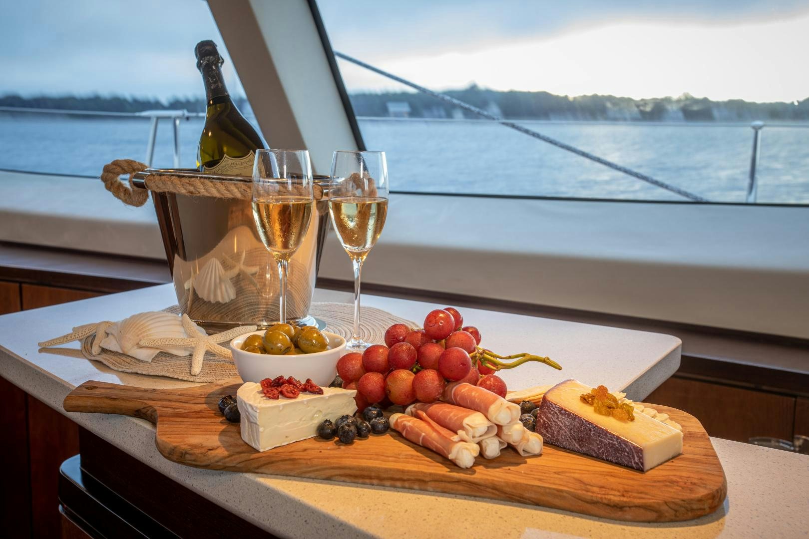 a bottle of wine on a table with food and a glass of wine aboard MIA CARA Yacht for Sale