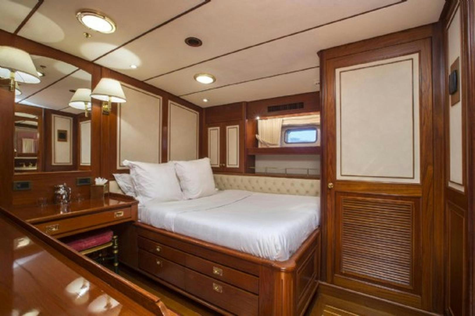 a bedroom with a bed and a mirror aboard GALILEO Yacht for Sale