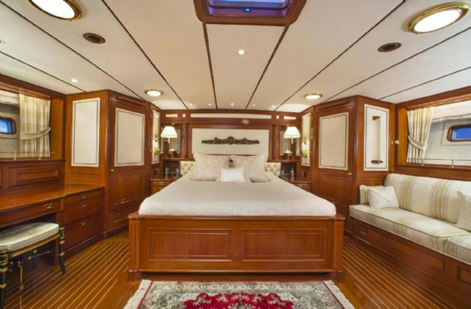 a bedroom with a bed and a couch aboard GALILEO Yacht for Sale