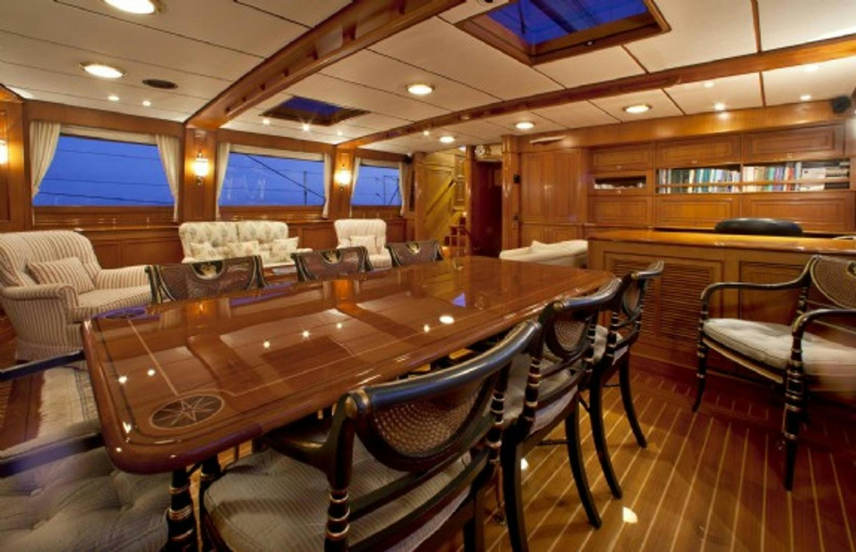 a large room with a table and chairs aboard GALILEO Yacht for Sale