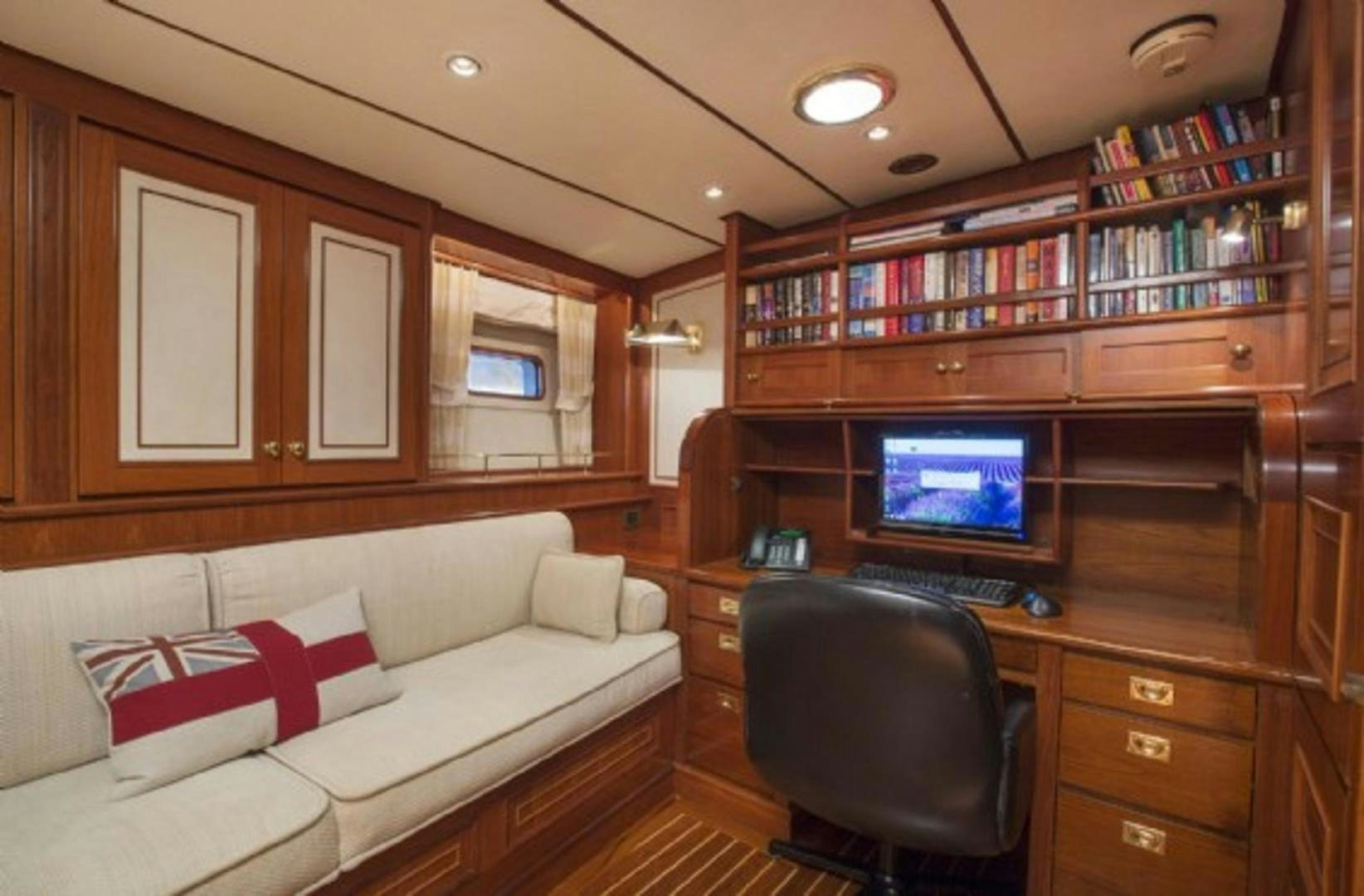 a living room with a laptop on a desk aboard GALILEO Yacht for Sale