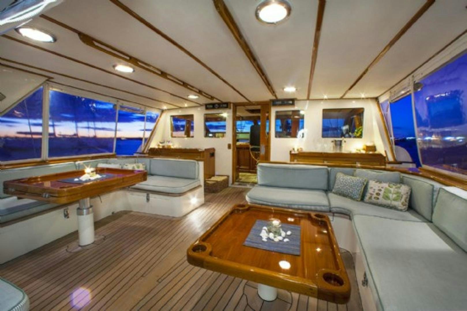 a living room with a table and couches aboard GALILEO Yacht for Sale