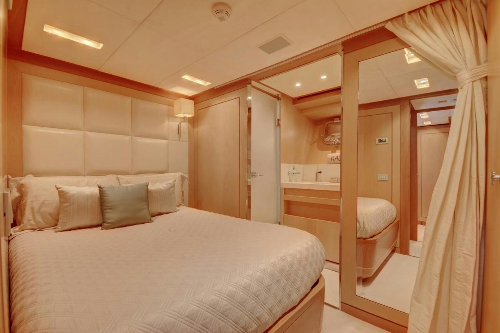 a bedroom with a bed and a mirror aboard KAOS Yacht for Sale