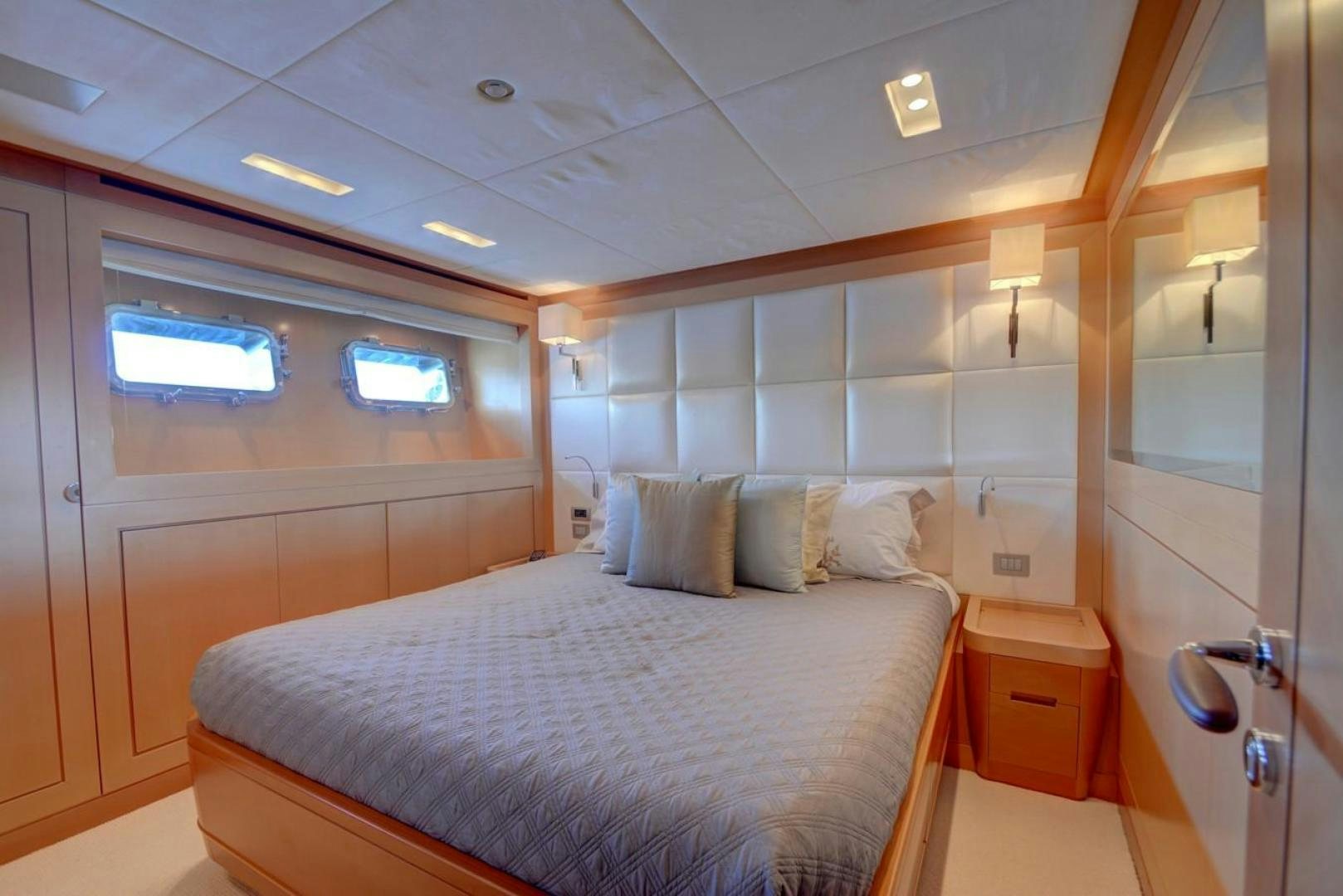 a bedroom with a bed and a mirror aboard KAOS Yacht for Sale