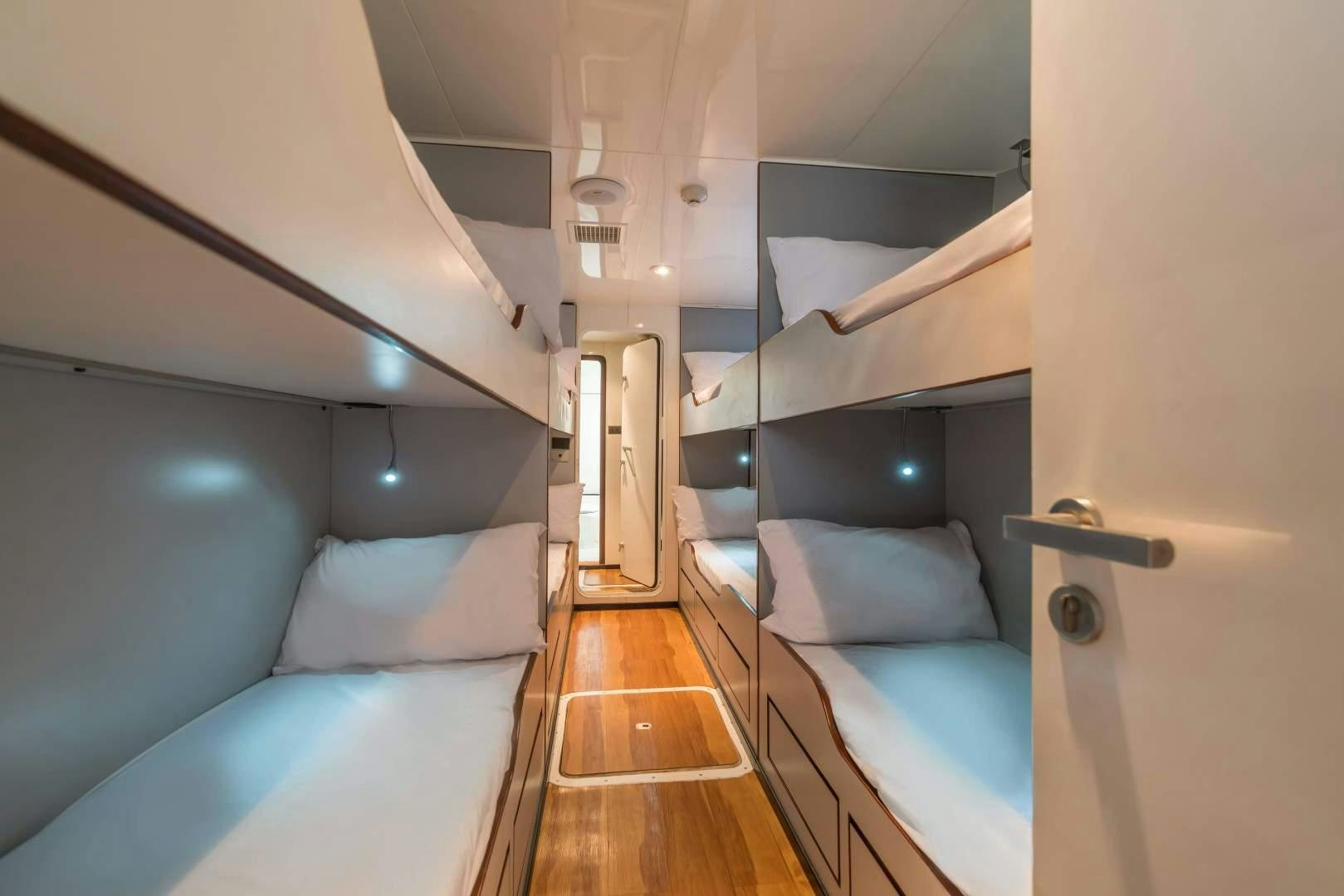 a room with a bed and a wood floor aboard PHATSARA Yacht for Sale