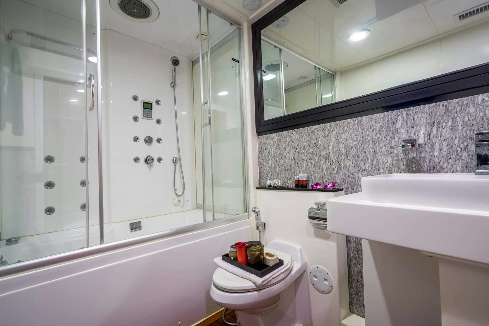 a bathroom with a glass shower aboard PHATSARA Yacht for Sale