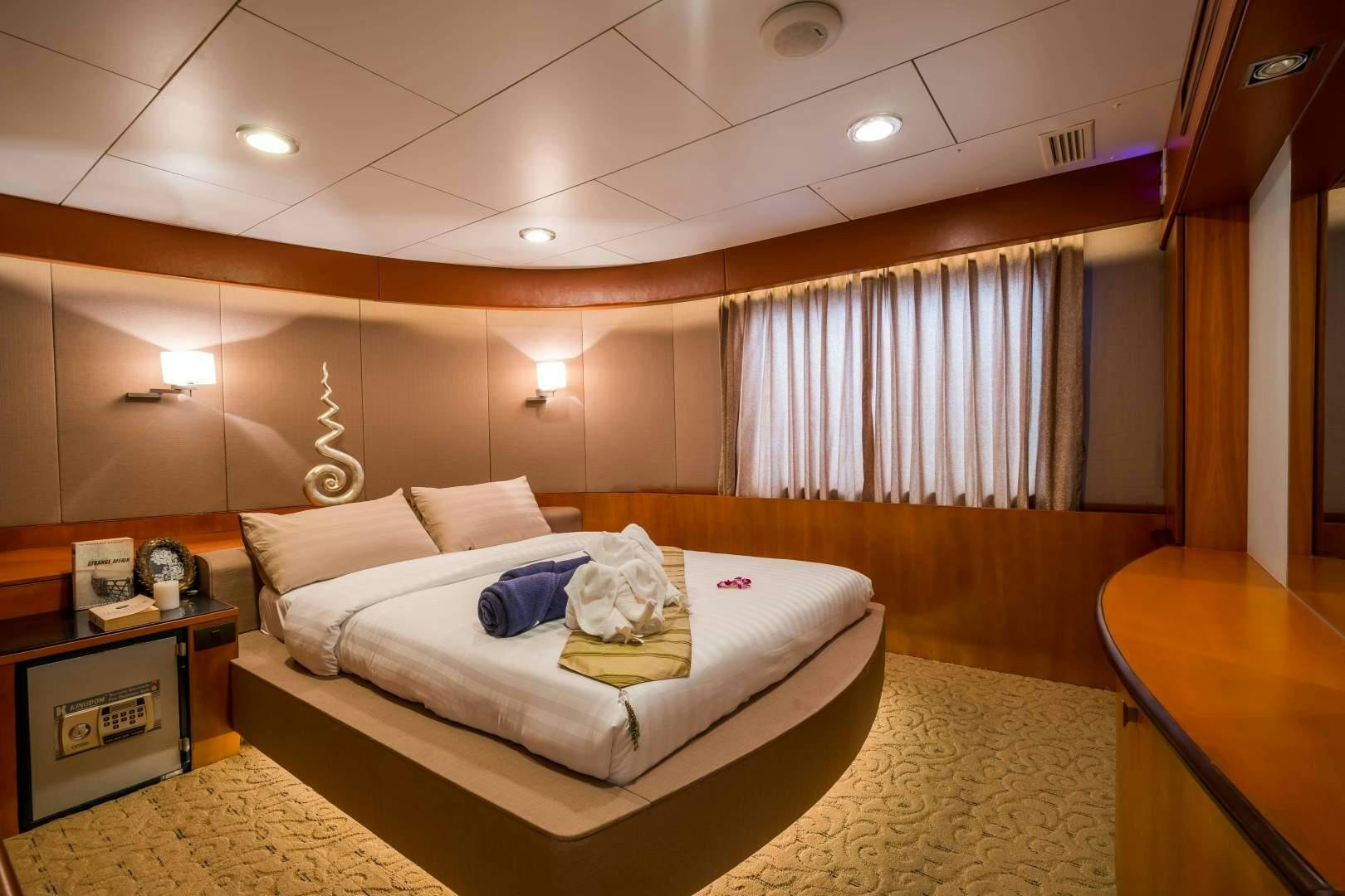 a room with a bed and a desk aboard PHATSARA Yacht for Sale