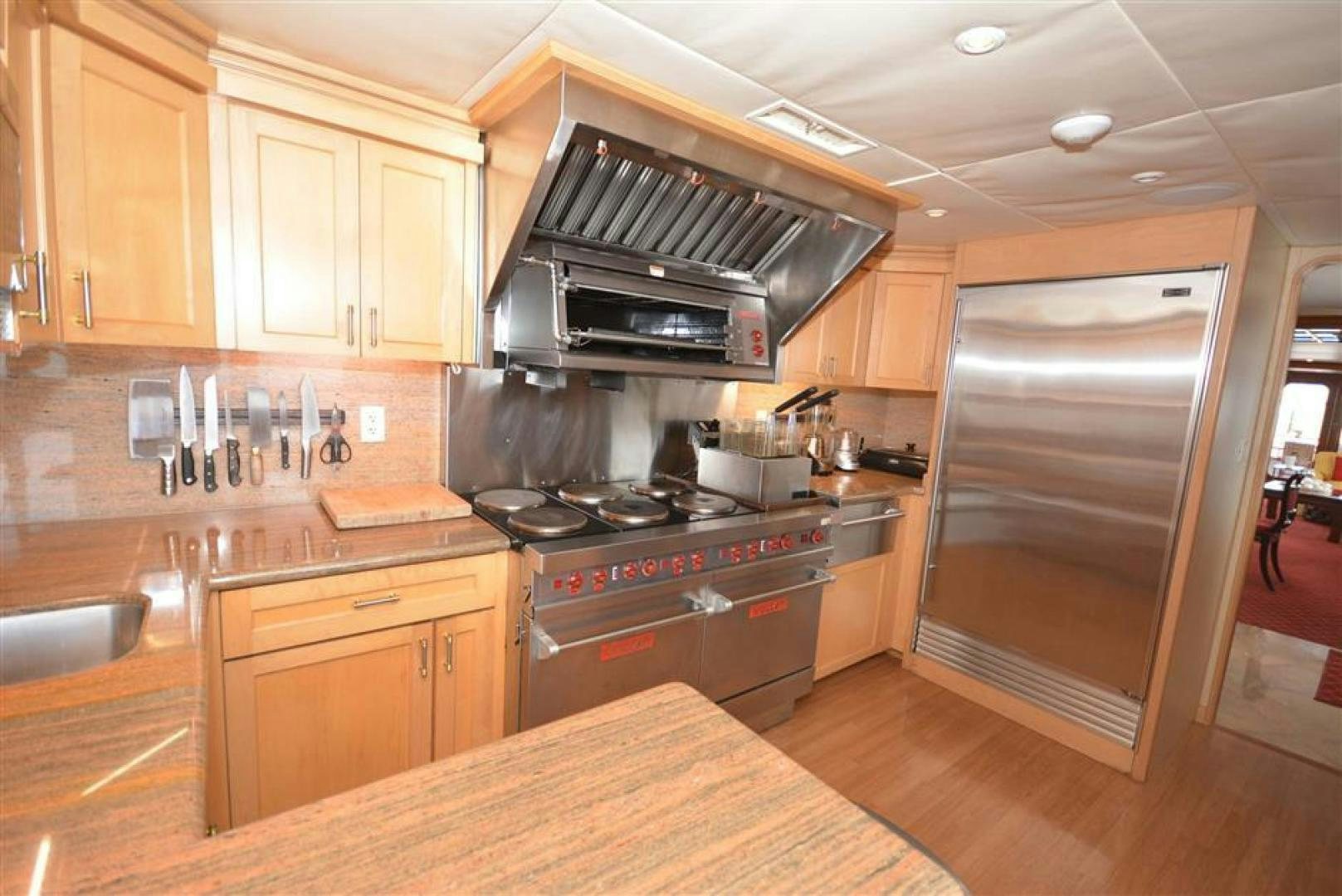 a kitchen with wooden cabinets aboard AR DE Yacht for Sale