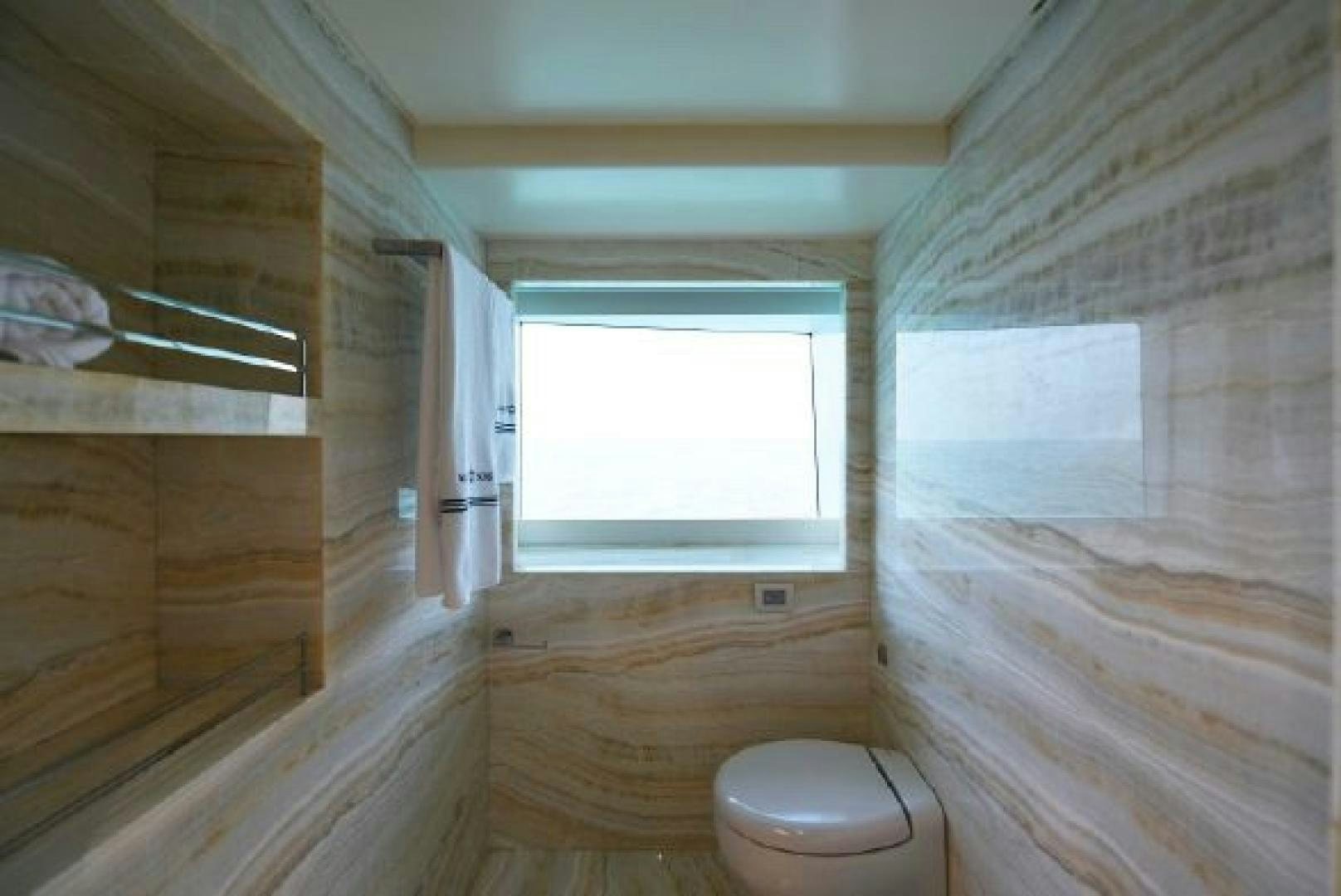 a bathroom with a toilet and a window aboard No Name Yacht for Sale