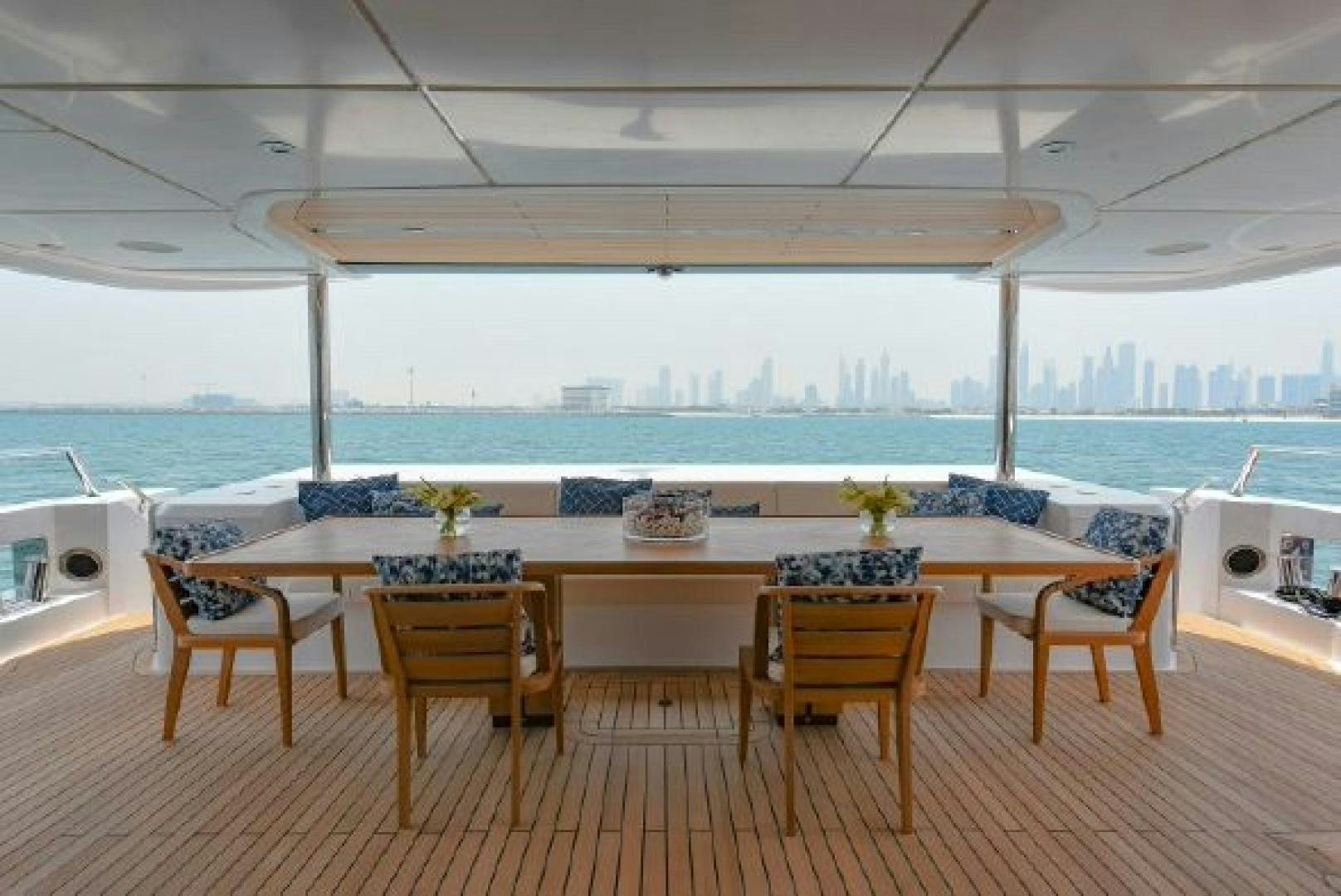 a table with chairs and a view of the ocean aboard No Name Yacht for Sale