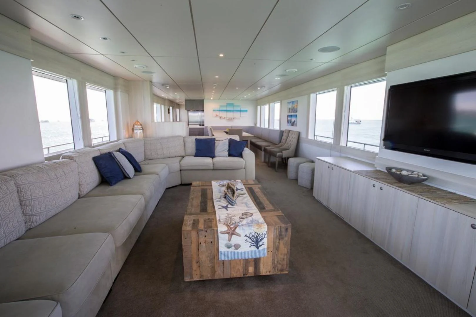 a living room with a large screen aboard KAHU Yacht for Sale