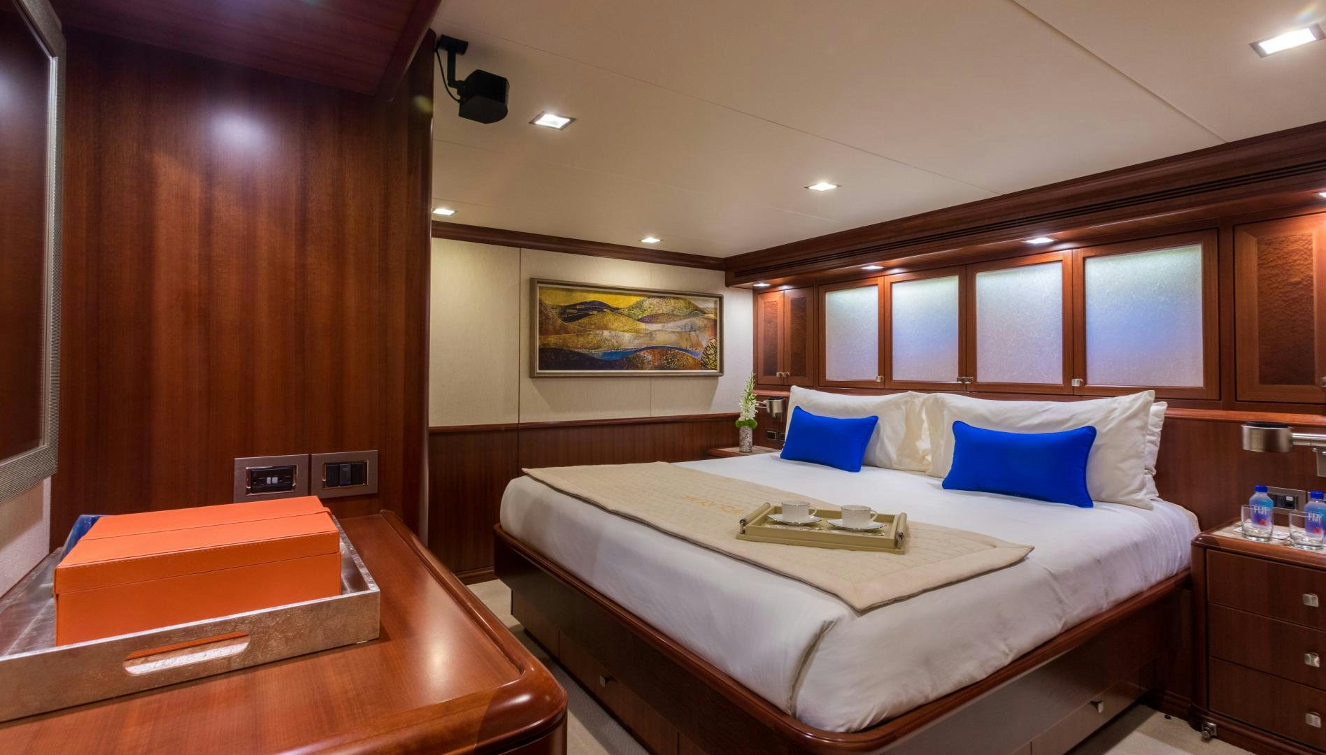 a bed with a white sheet and blue pillows aboard MY AURORA Yacht for Sale