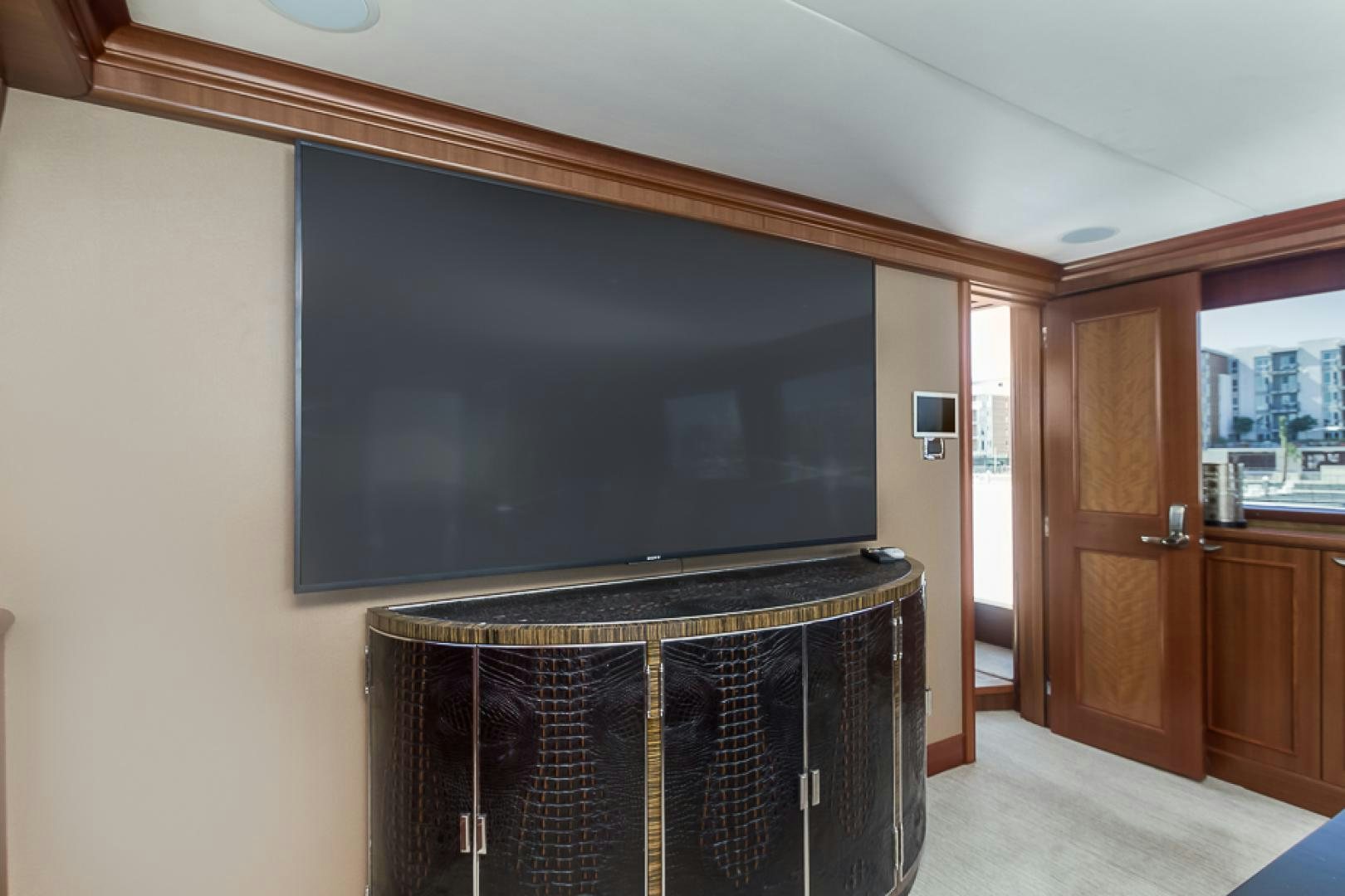 a room with a television and a wood cabinet aboard LIQUIDITY Yacht for Sale