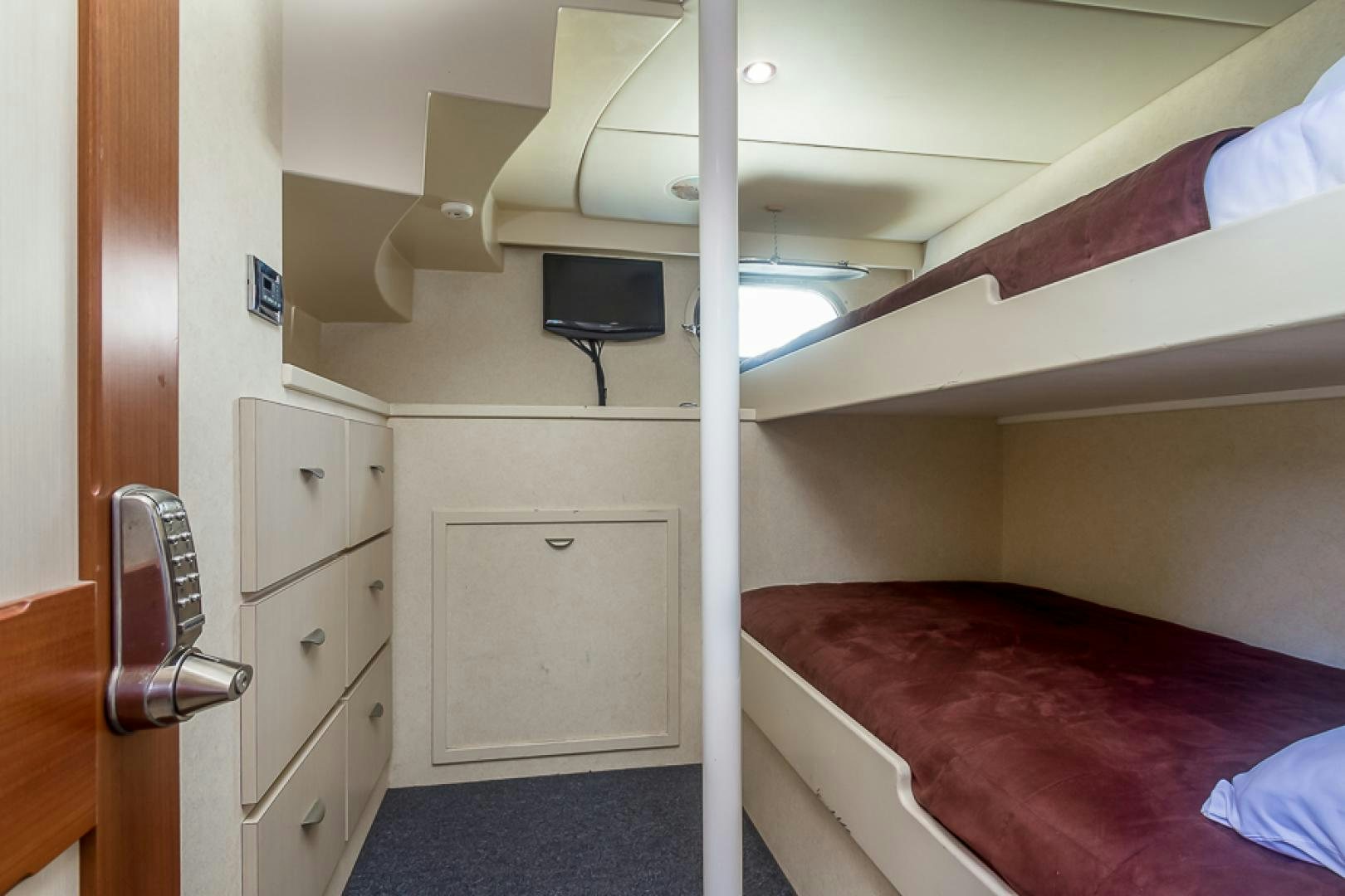 a small bedroom with a bed and a tv aboard LIQUIDITY Yacht for Sale