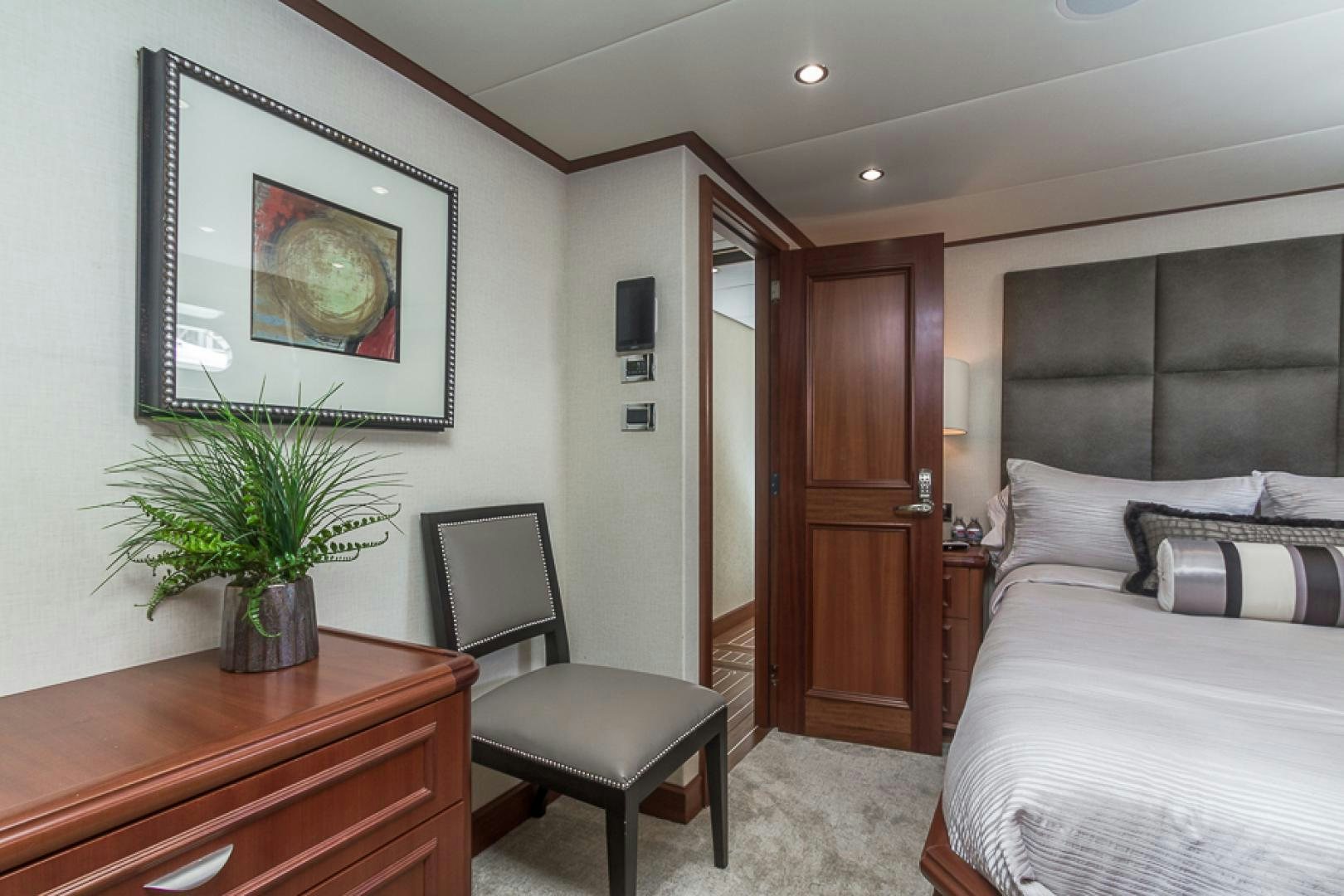 a bedroom with a bed and a chair aboard LIQUIDITY Yacht for Sale