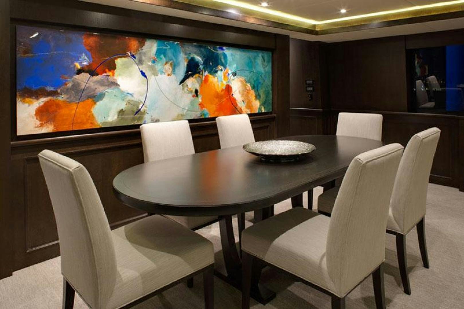 a table with chairs and a television in the background aboard ENCORE Yacht for Sale