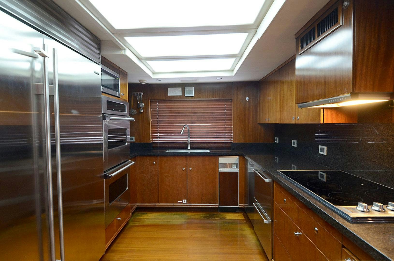 a kitchen with wooden cabinets aboard OCEAN CLUB Yacht for Sale
