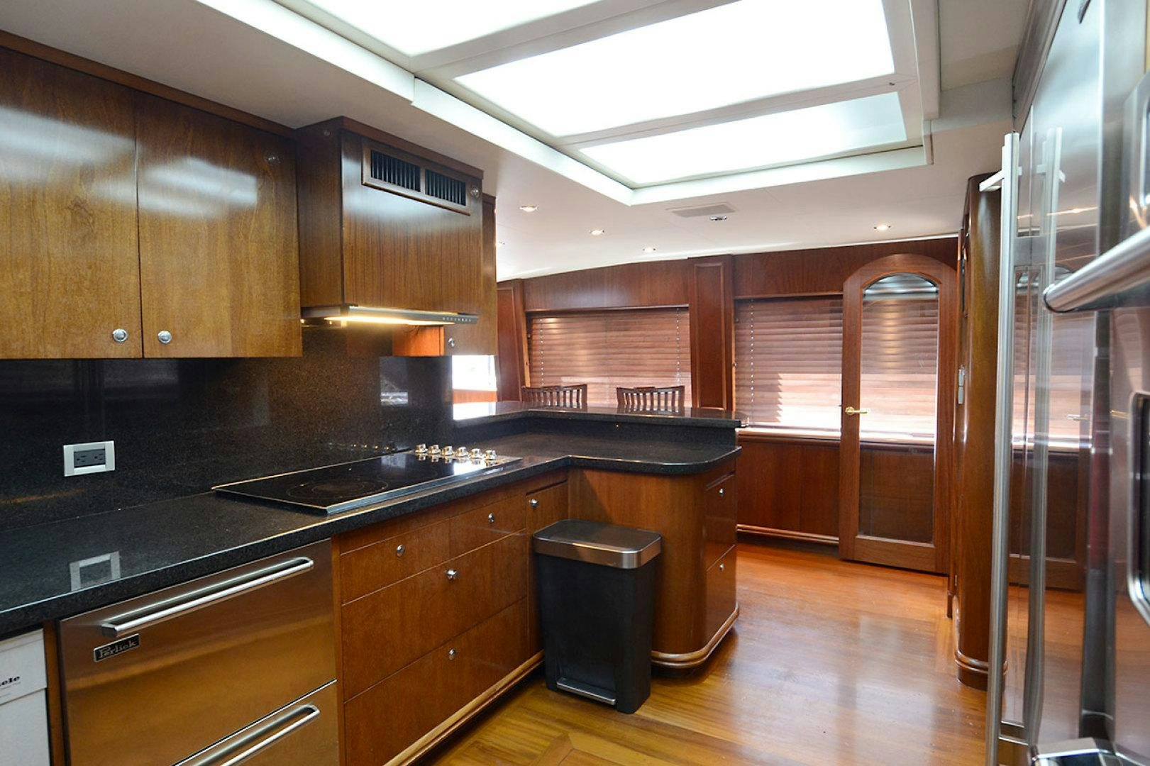a kitchen with wooden cabinets aboard OCEAN CLUB Yacht for Sale