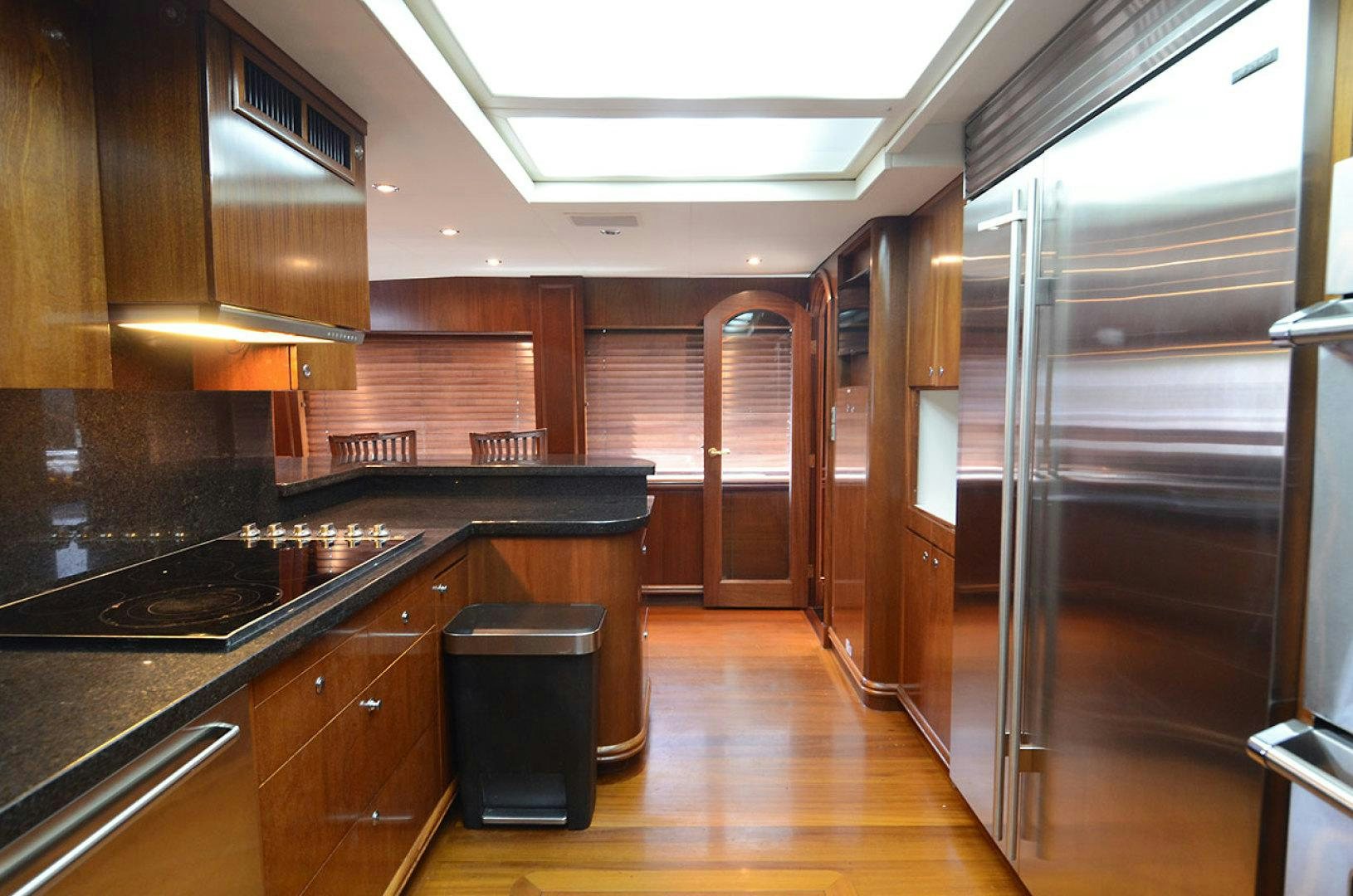 a kitchen with wooden cabinets aboard OCEAN CLUB Yacht for Sale