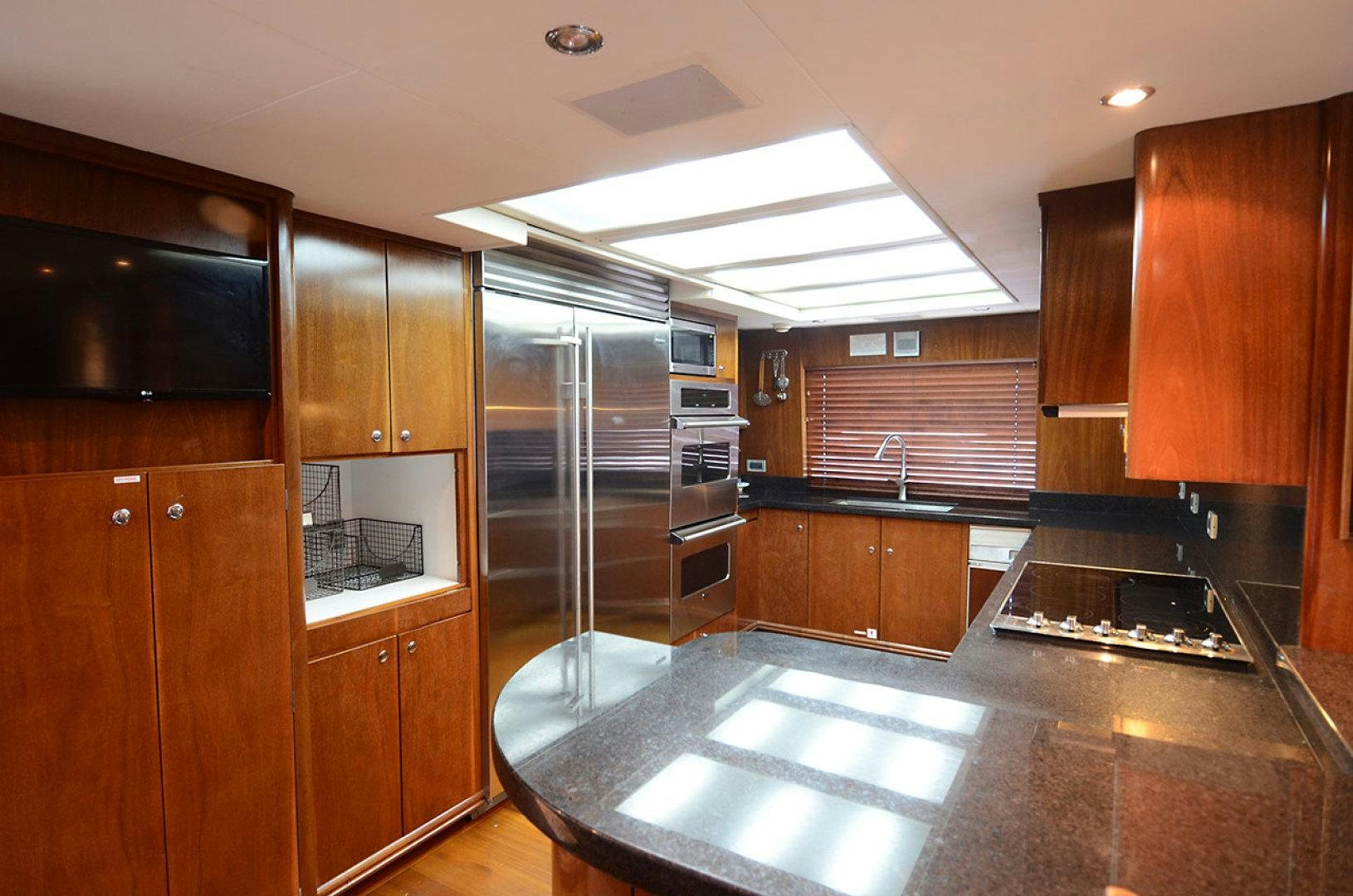 a kitchen with wooden cabinets aboard OCEAN CLUB Yacht for Sale