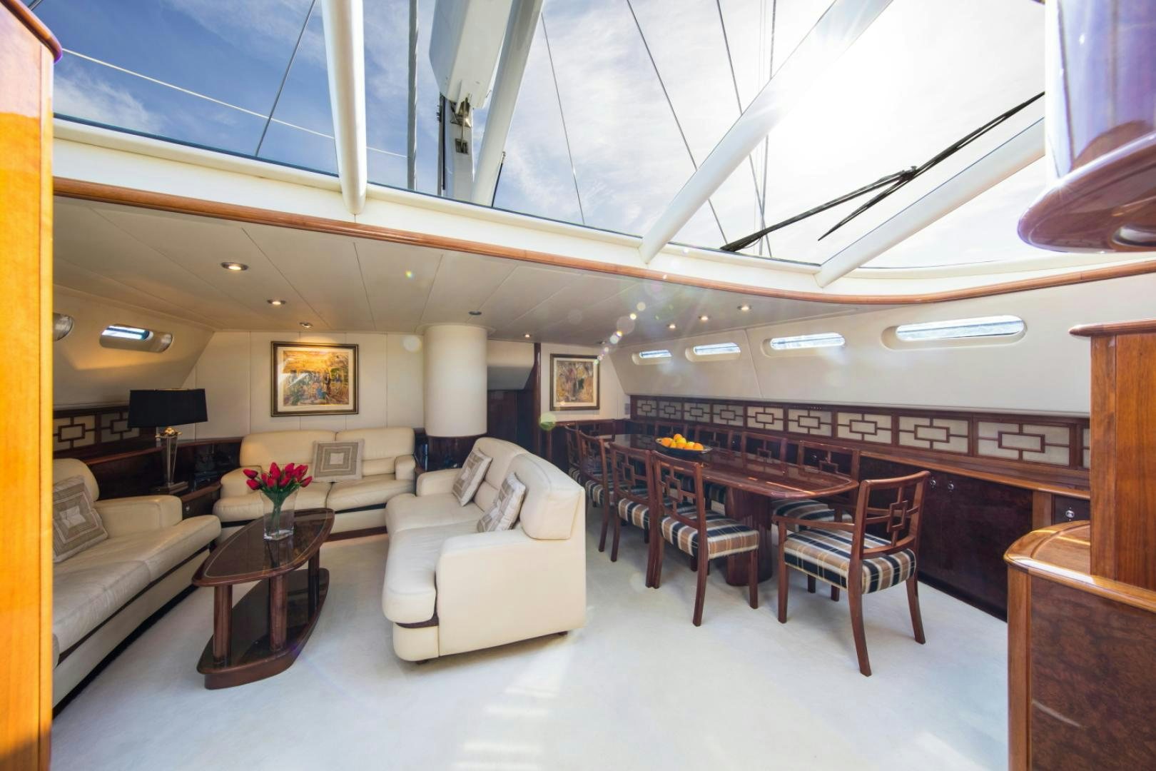 a large living room with a white couch and a large chandelier aboard SOVEREIGN Yacht for Sale