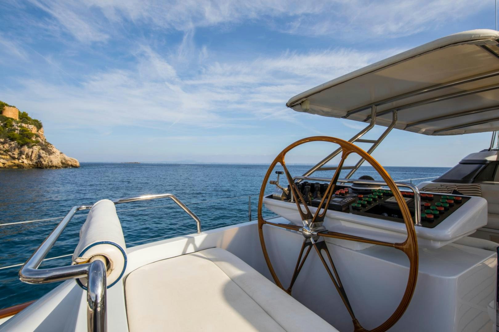 a boat with a steering wheel and a view of the ocean aboard SOVEREIGN Yacht for Sale