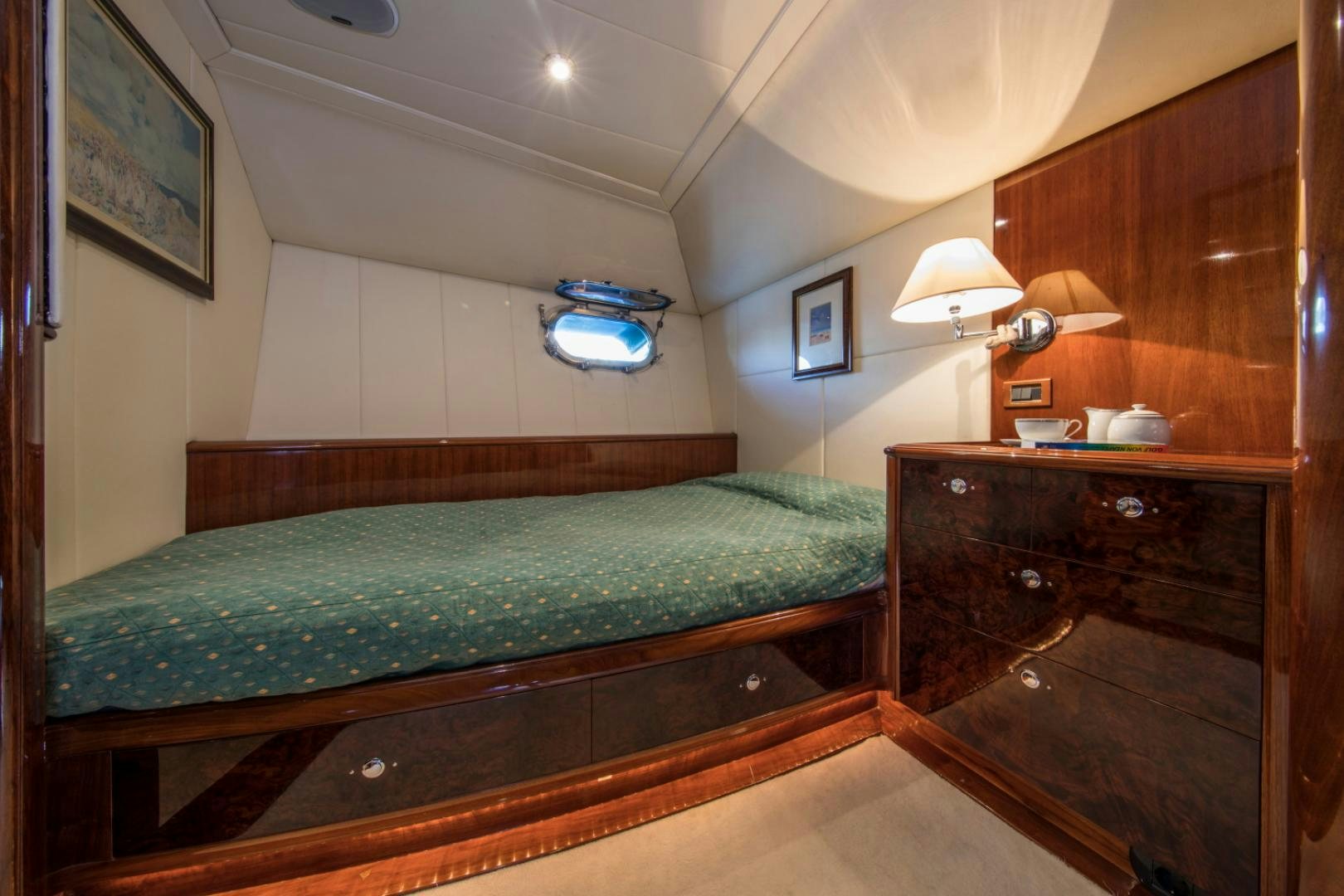 a bedroom with a bed and a dresser aboard SOVEREIGN Yacht for Sale