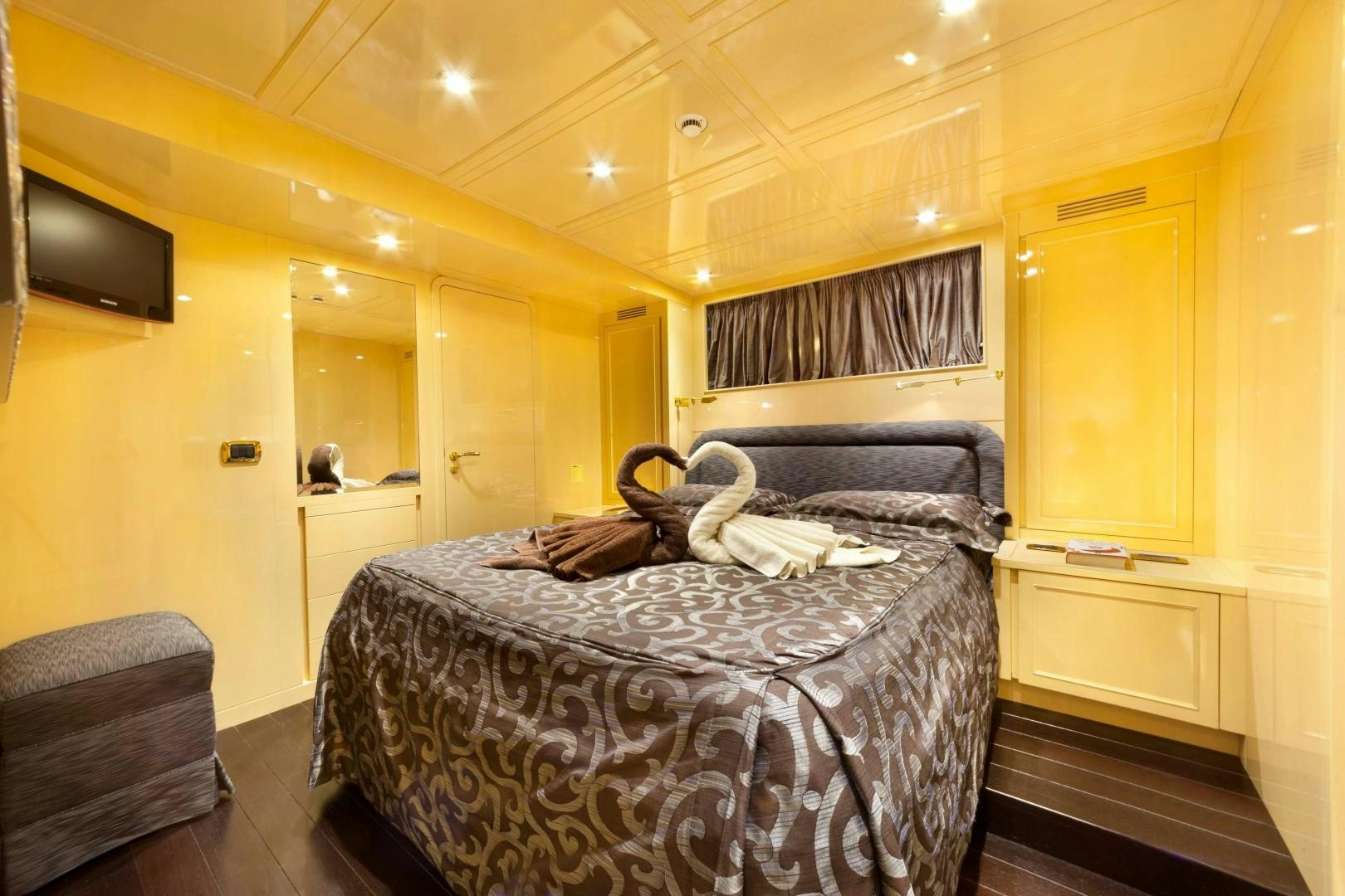 a bedroom with a bed and a chair aboard DISCO VOLANTE Yacht for Sale