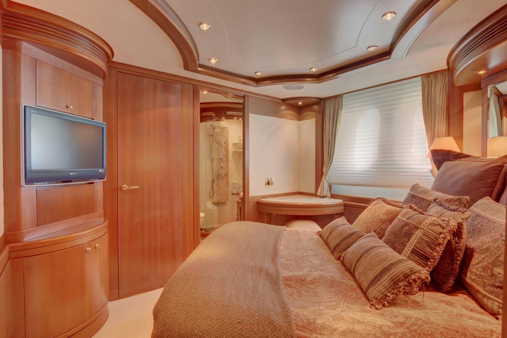 a bedroom with a bed and a television aboard SIN OR SWIM Yacht for Sale