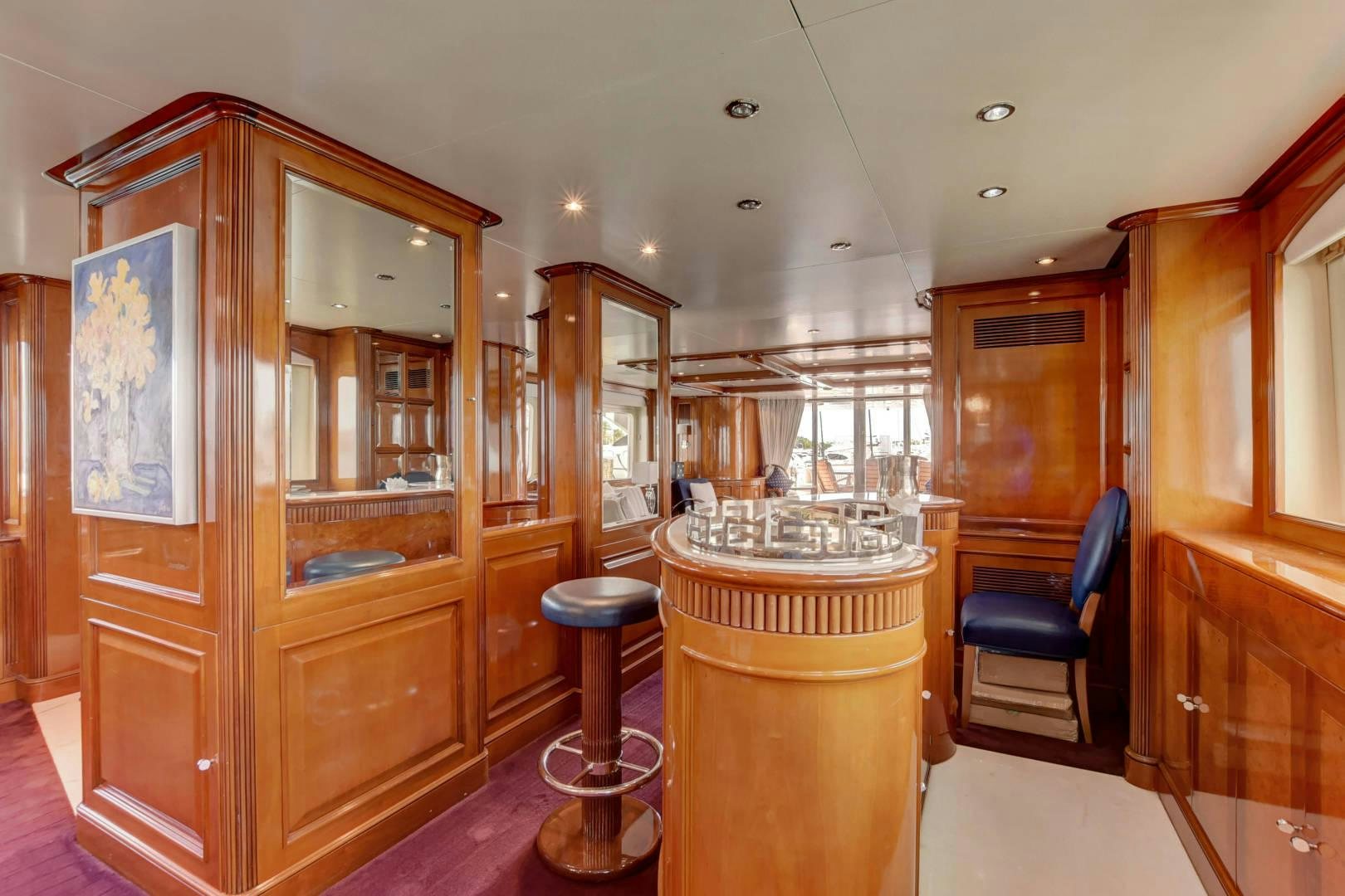 a kitchen with a bar and stools aboard PARADIGM Yacht for Sale