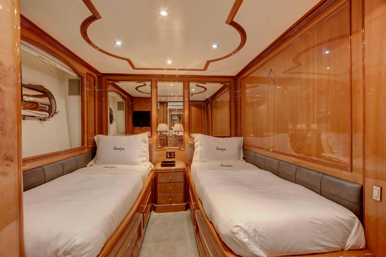 a room with beds and a mirror aboard PARADIGM Yacht for Sale
