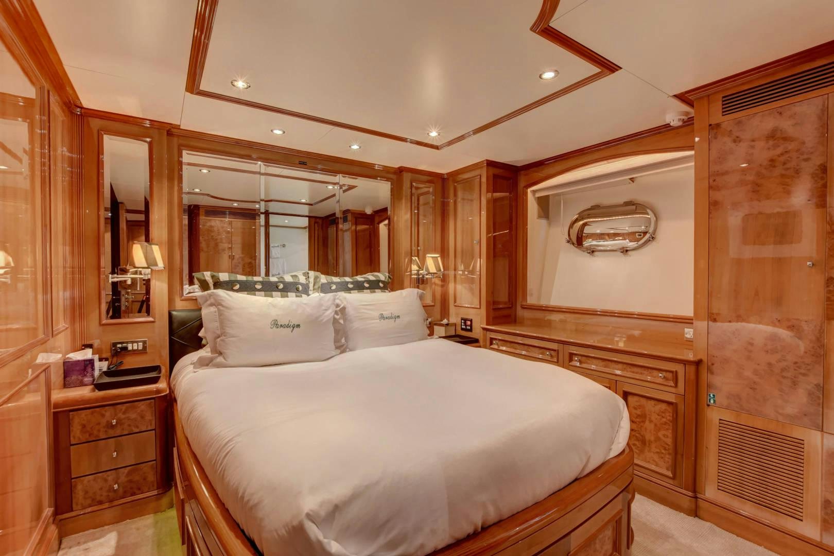 a bedroom with a bed and a mirror aboard PARADIGM Yacht for Sale