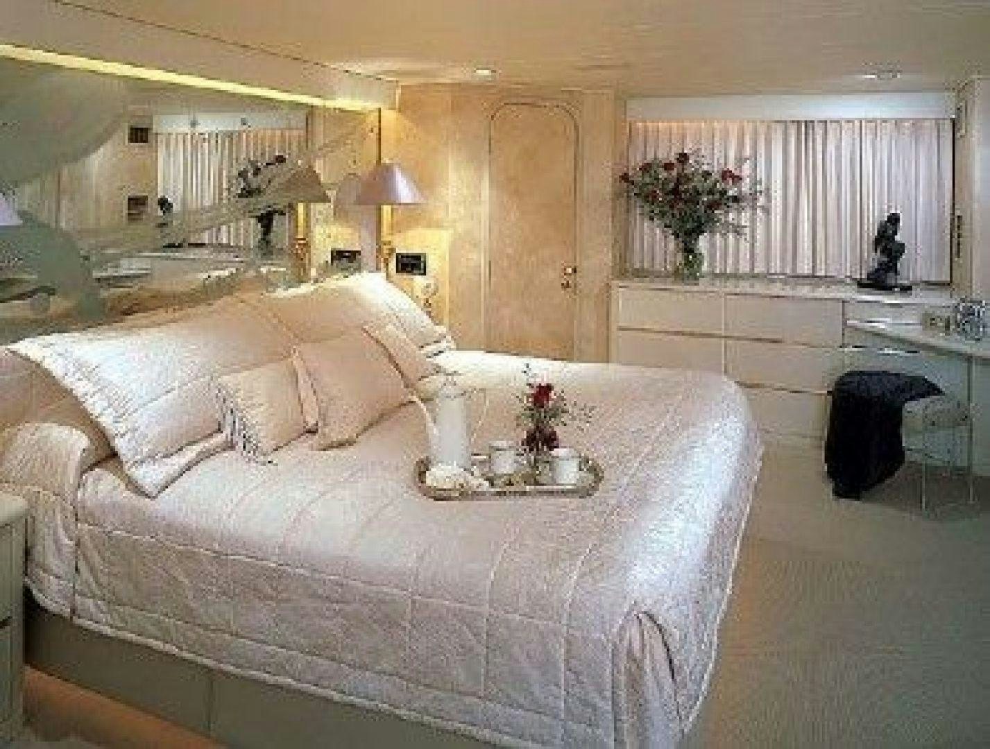 a bed with a white bed spread aboard THUNDERBALL Yacht for Sale