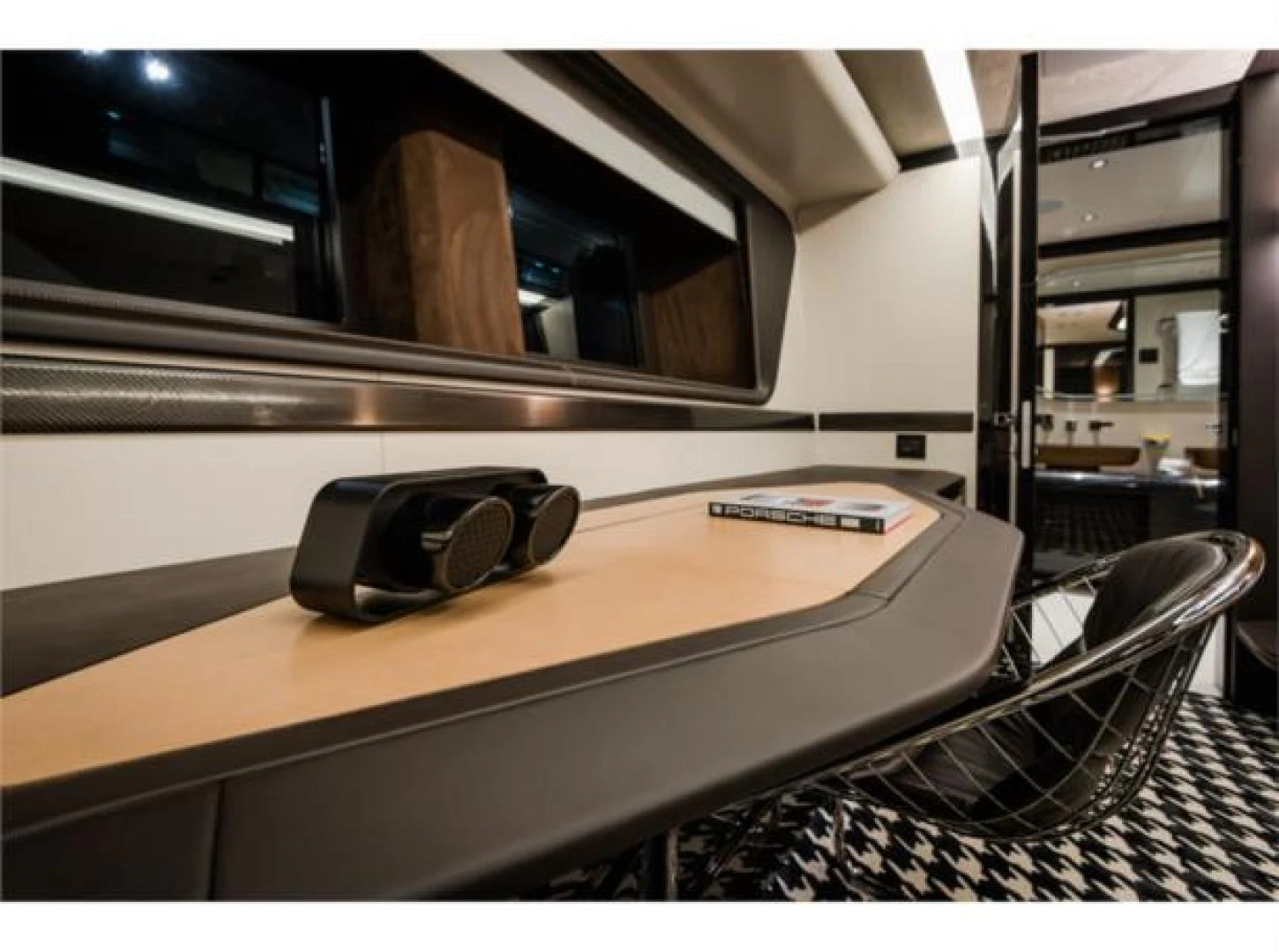 a desk with a computer and headphones on it aboard GTT 115 HYBRID Yacht for Sale