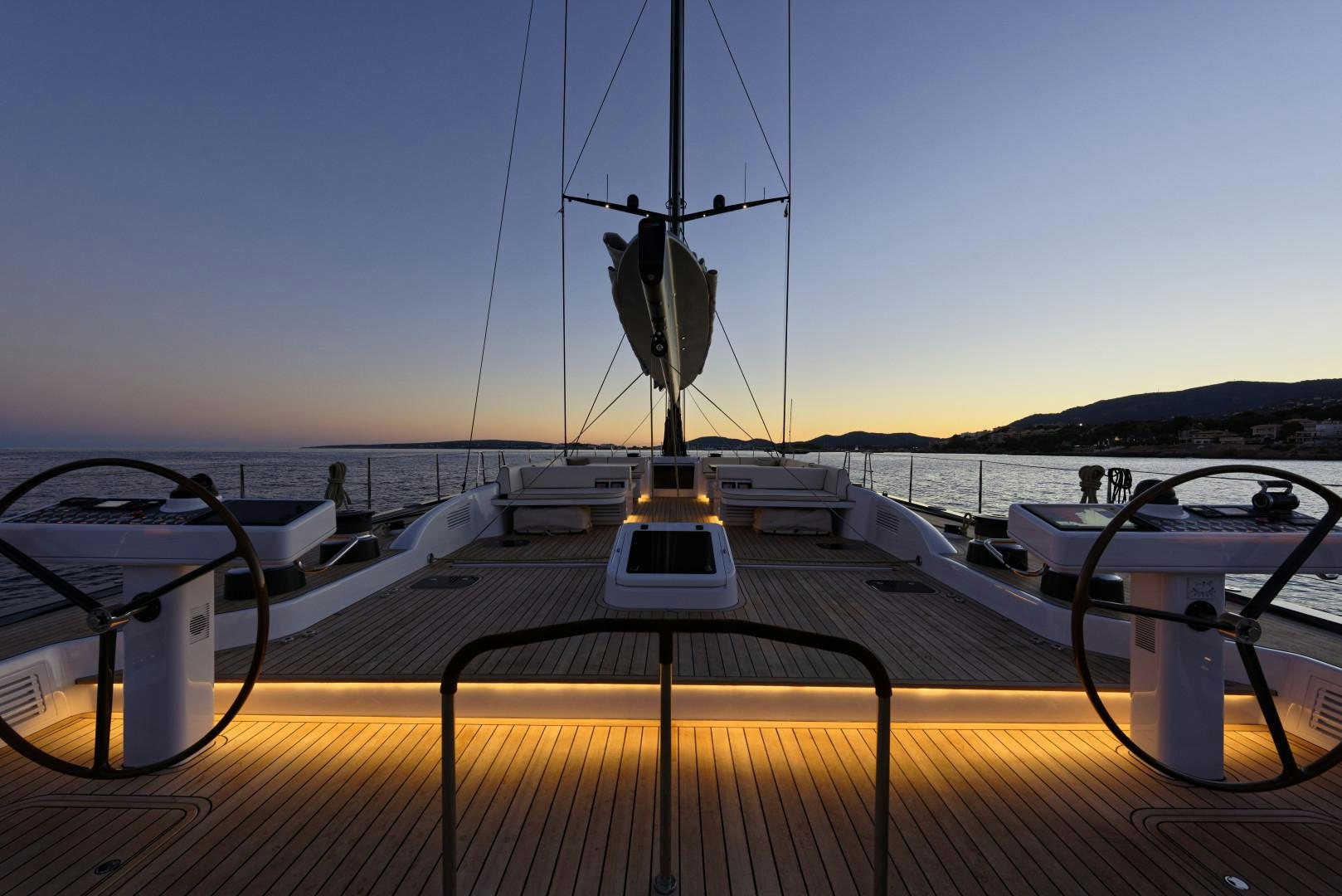 a deck with a boat and a railing with a body of water in the background aboard DARLIN Yacht for Sale